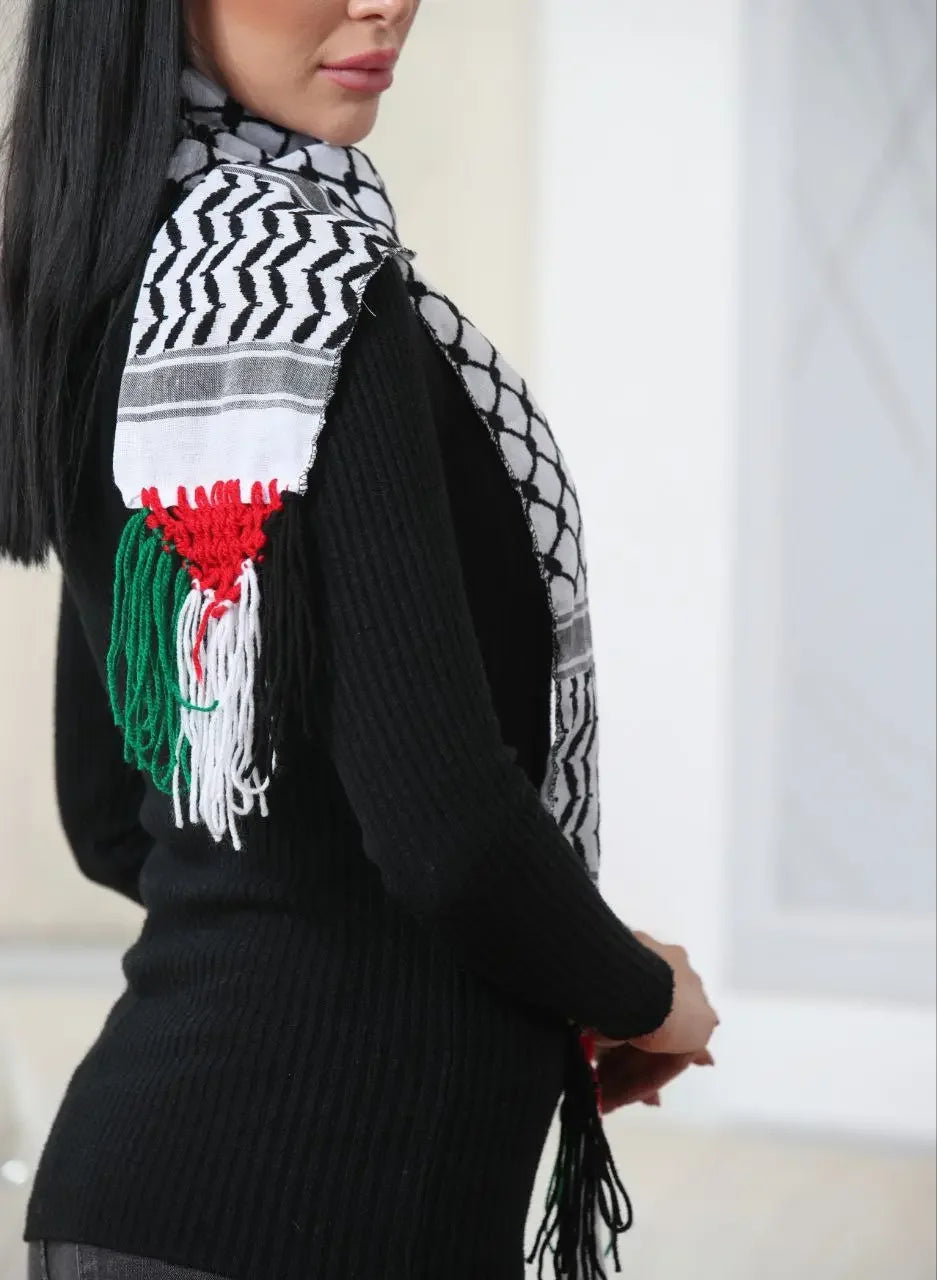 Woman wearing an authentic Palestinian keffiyeh scarf with traditional black and white patterns and red, green, and white fringes