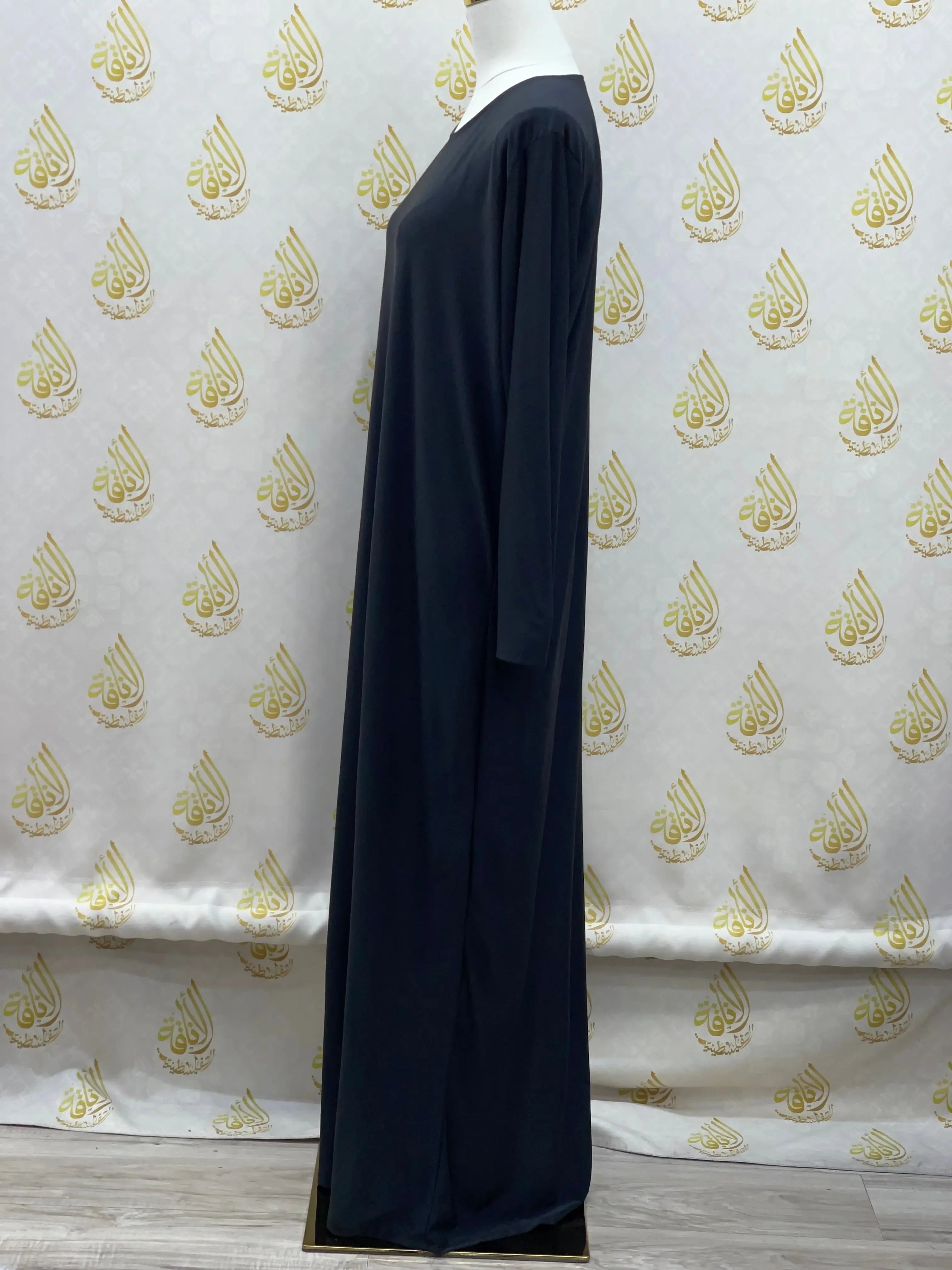 Palestinian Elegance black basic solid dress with long sleeves displayed on a mannequin side view