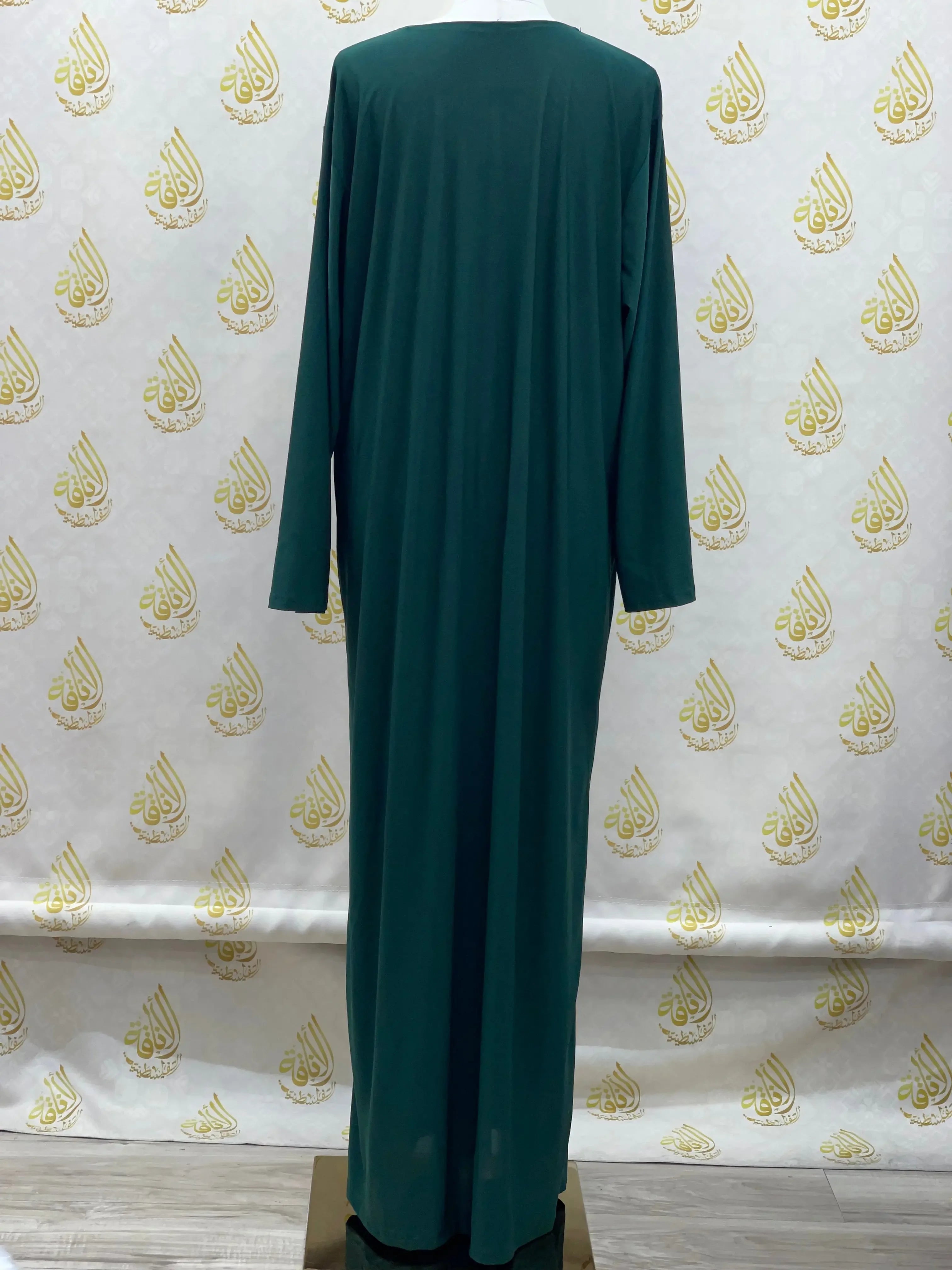 Palestinian elegance long sleeve basic solid dress in dark green displayed on mannequin