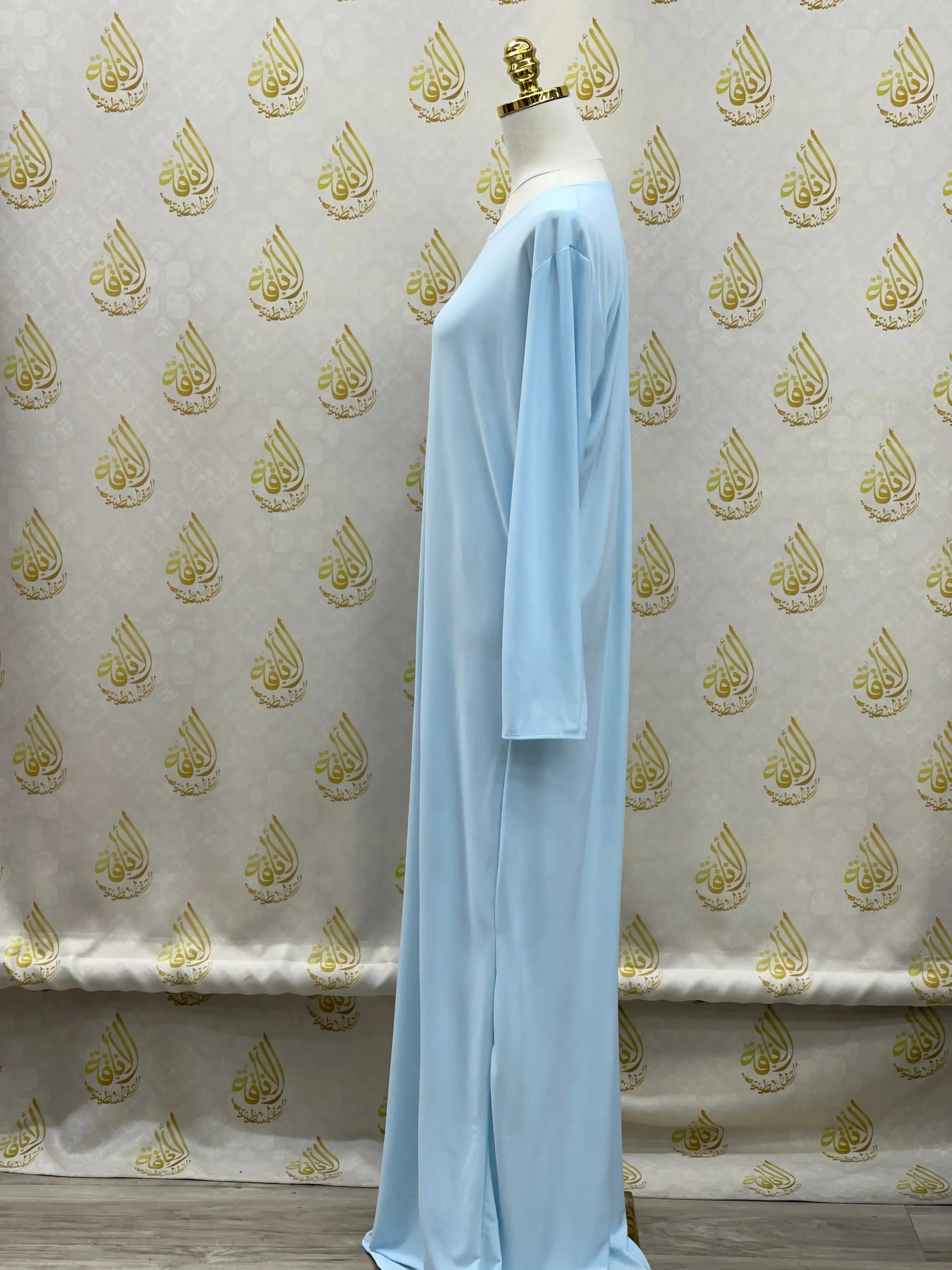 Palestinian elegance light blue basic solid dress with long sleeves displayed on a mannequin
