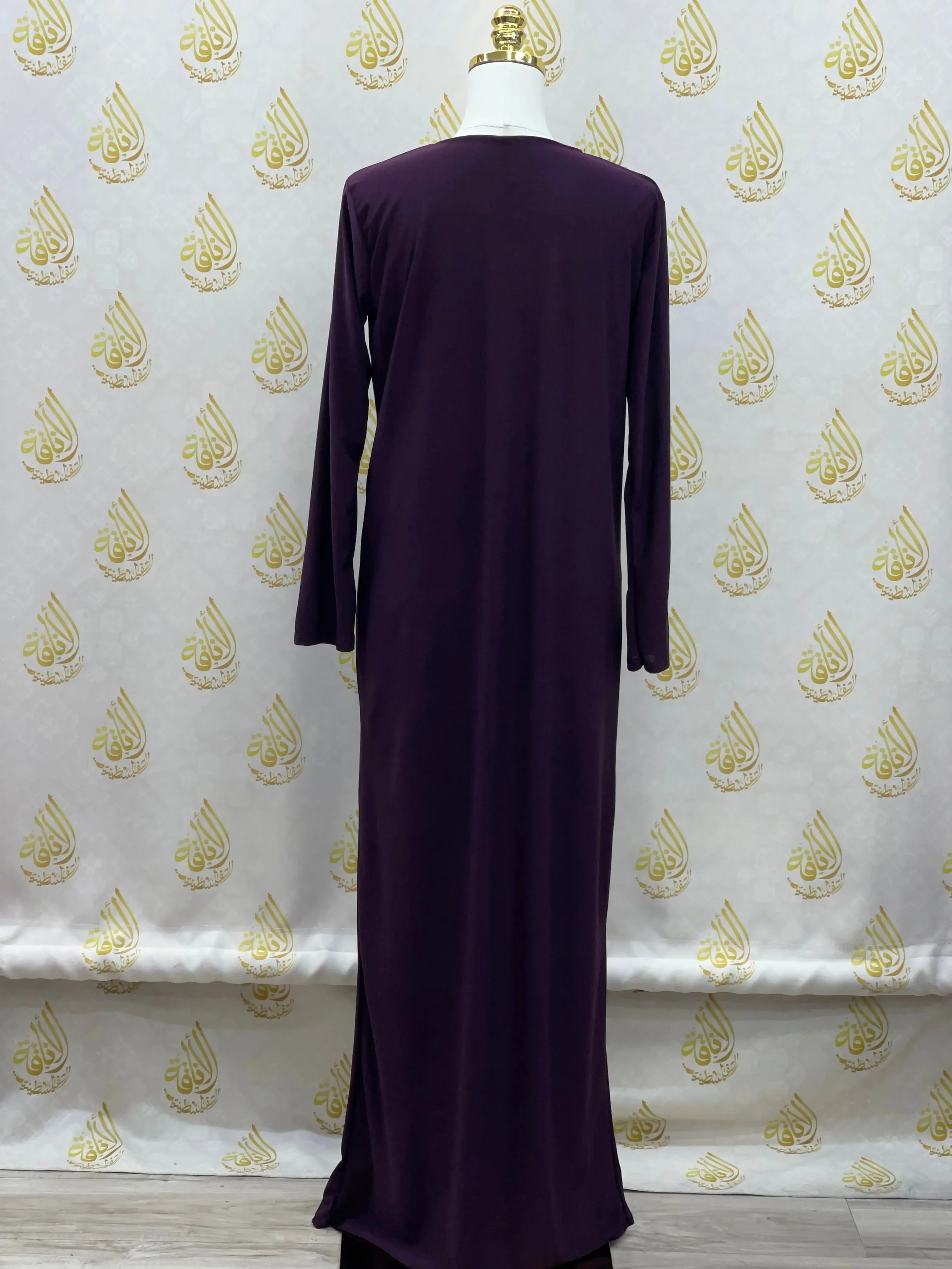 Back view of palestinian elegance basic solid dress in dark purple with long sleeves and simple design