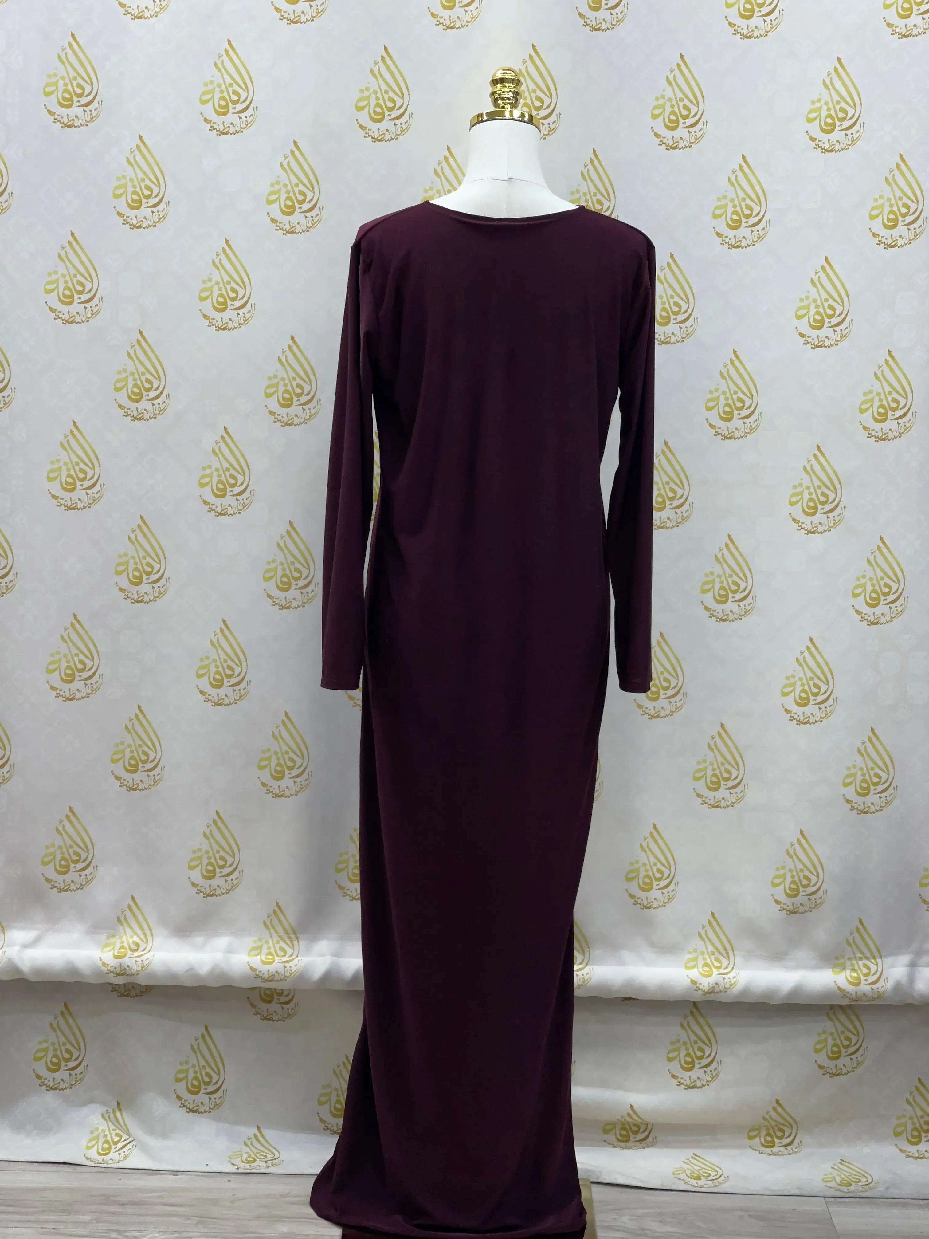 Palestinian elegance long sleeve basic solid dress in deep purple displayed on mannequin