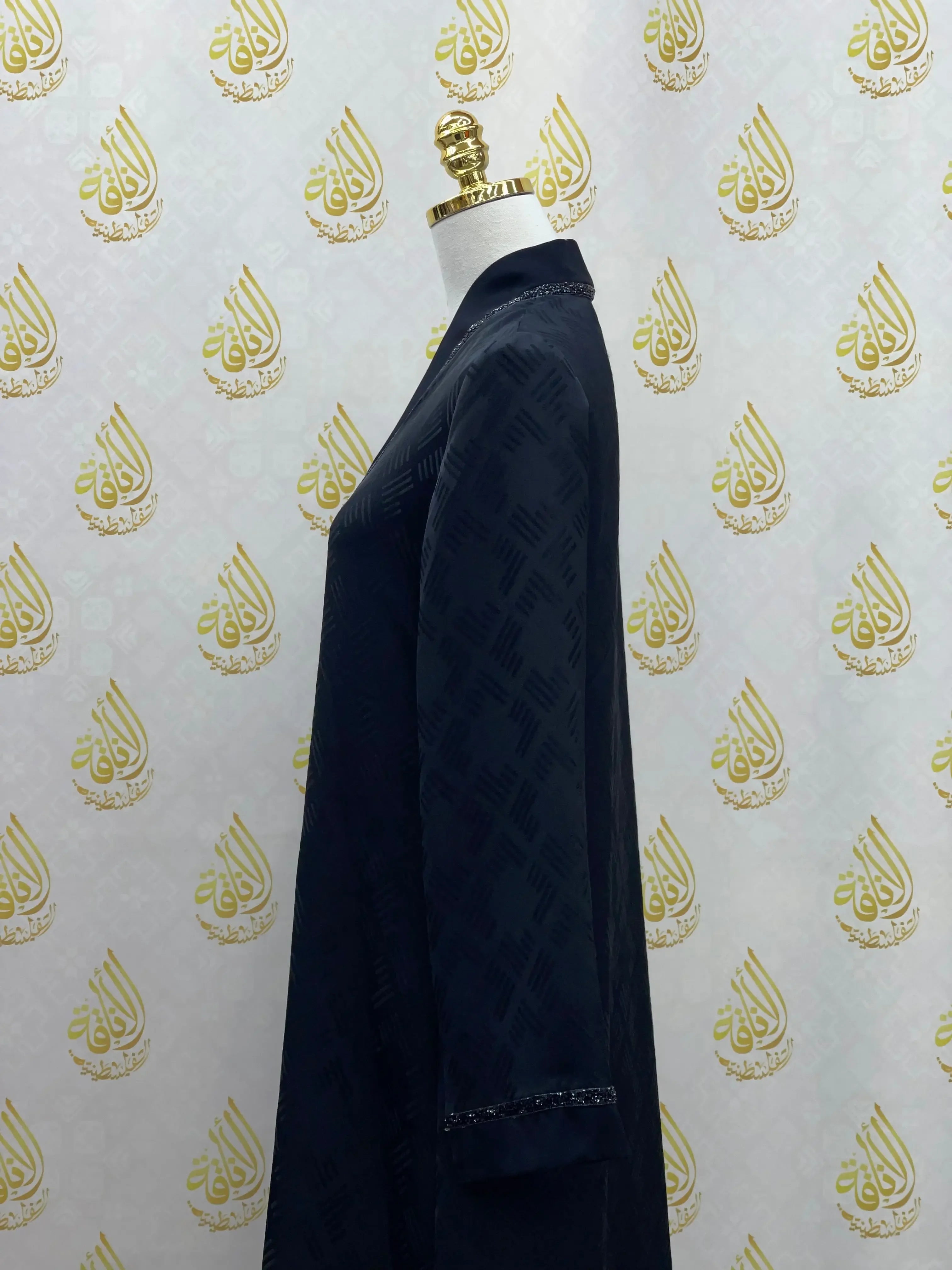 Side view of a black abaya for women from Palestinian Elegance with subtle pattern and cuff details