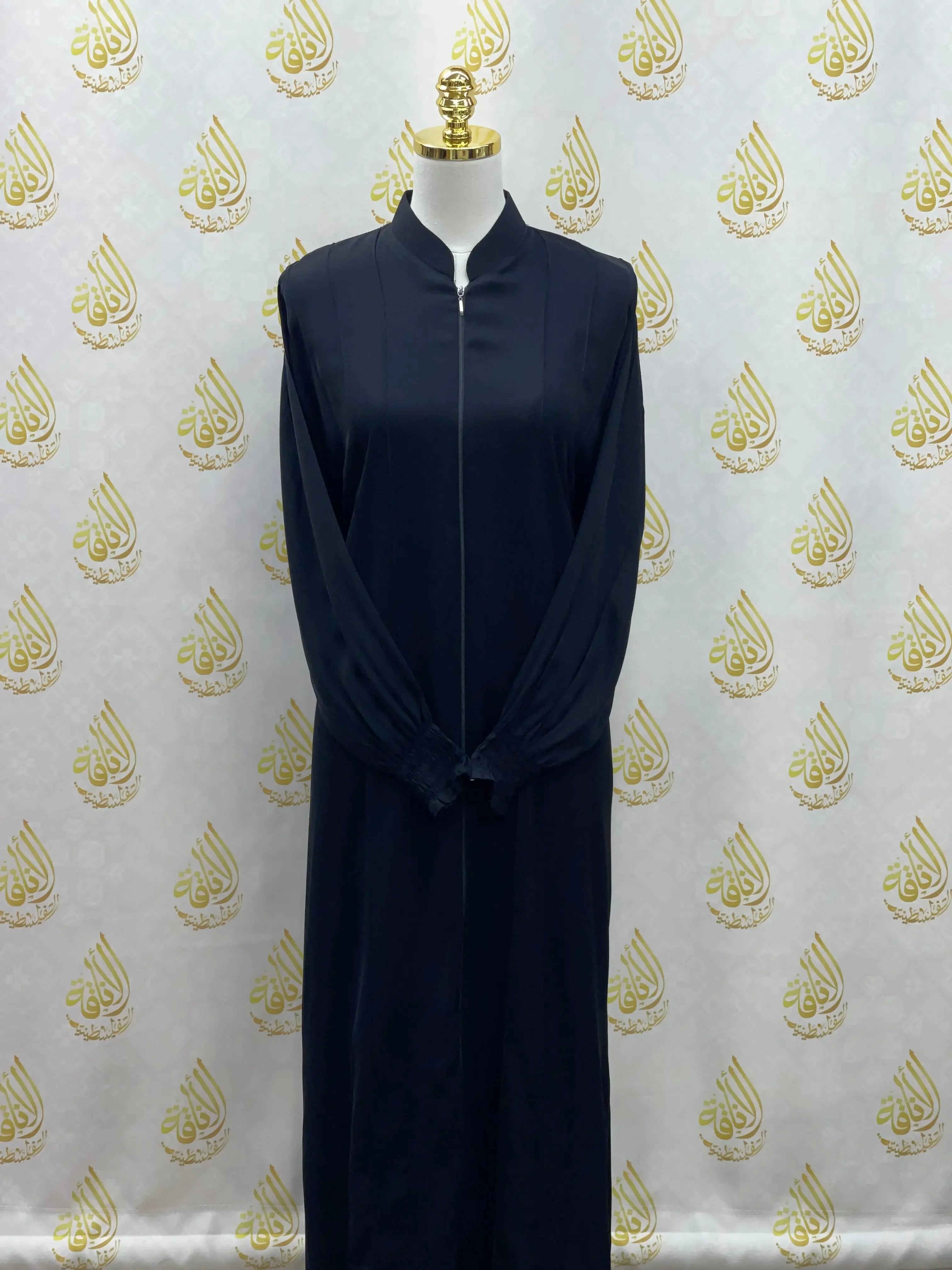 Black abaya with embroidery by Palestinian Elegance displayed on mannequin with long sleeves and front zipper