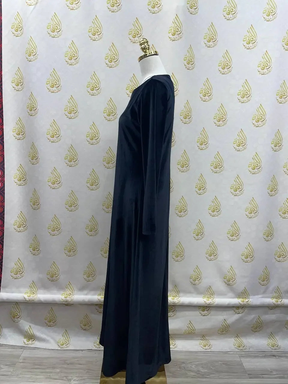 Palestinian Elegance black velvet maxi dress for women displayed on mannequin against decorative backdrop