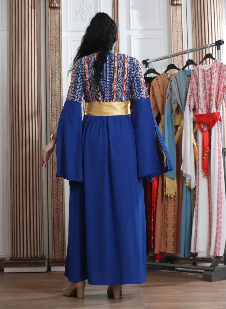 Back view of a woman wearing a blue embroidered Manjel dress with gold belt from Palestinian Elegance