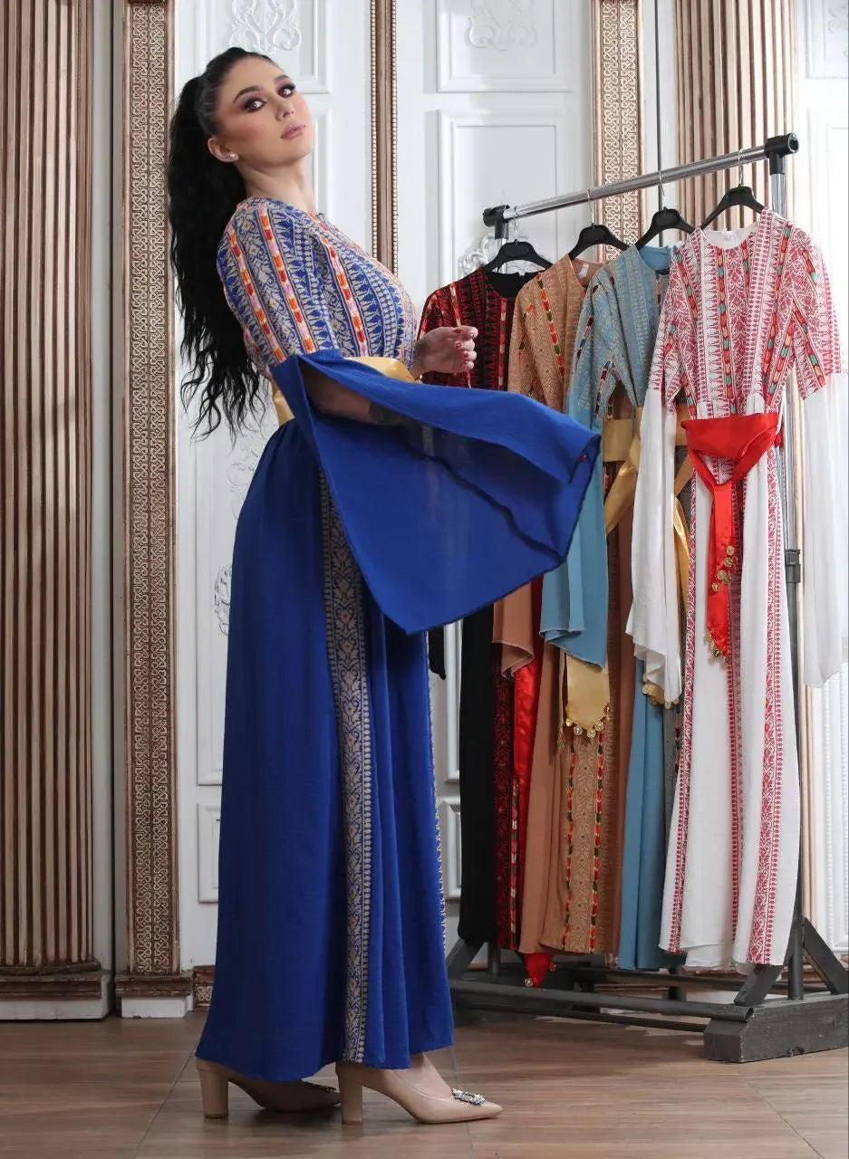 Woman wearing a blue embroidered Manjel dress with traditional Palestinian designs by Palestinian Elegance