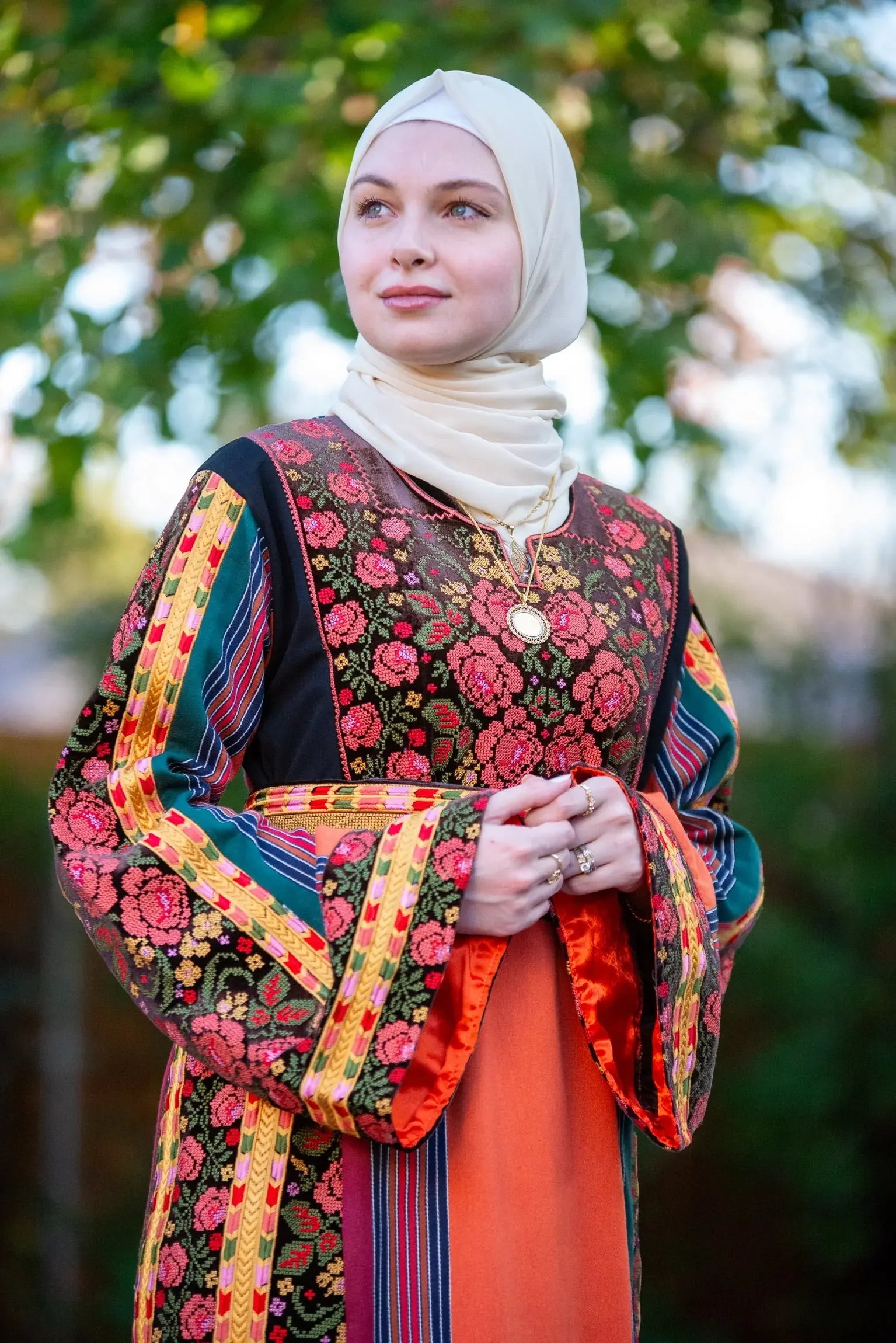 Palestinian Elegance Brown Velvet Orange Majdlawi Thoub with intricate floral embroidery and colorful striped sleeves