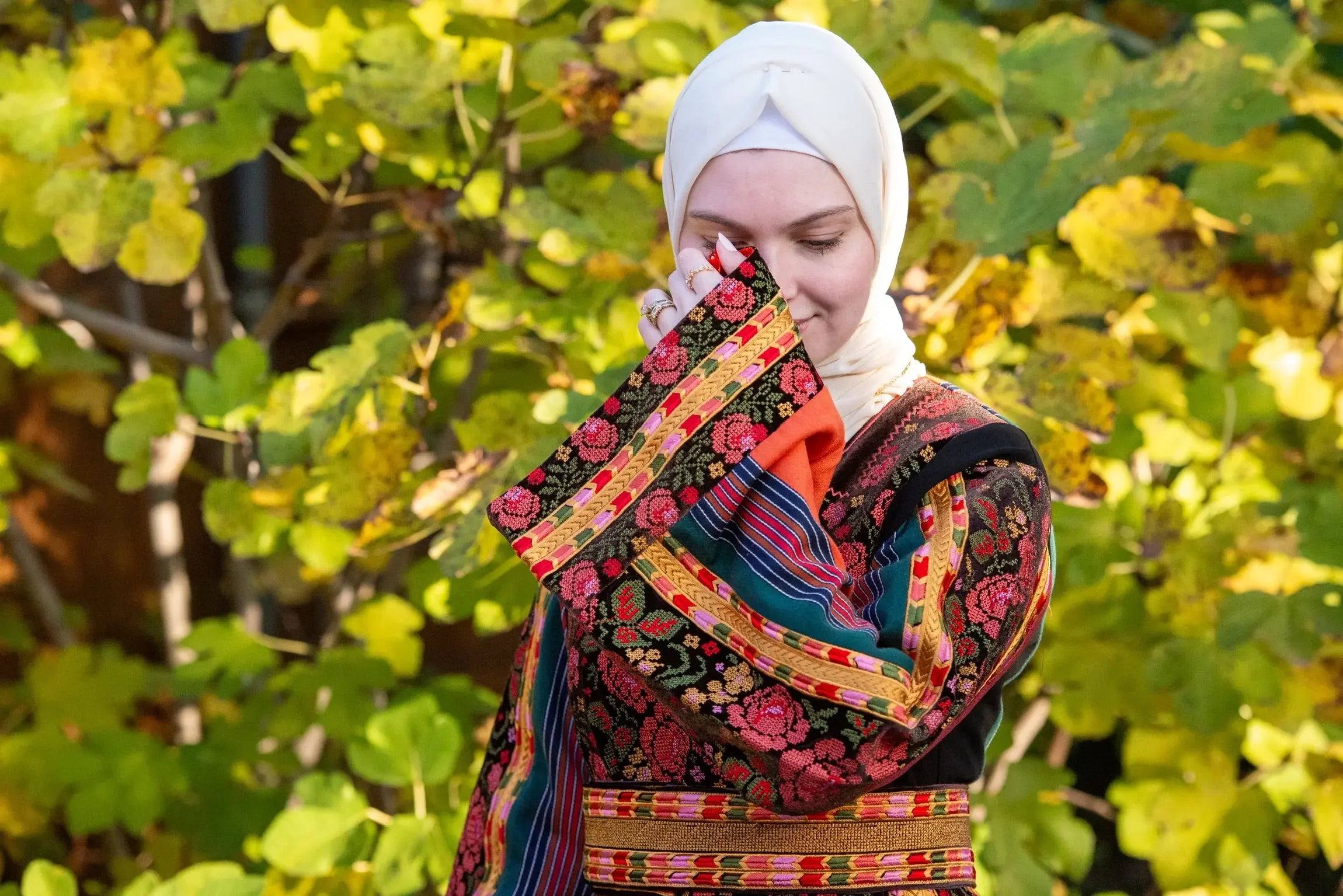 Woman wearing Brown Velvet Orange Majdlawi Thoub embroidery by Palestinian Elegance outdoors
