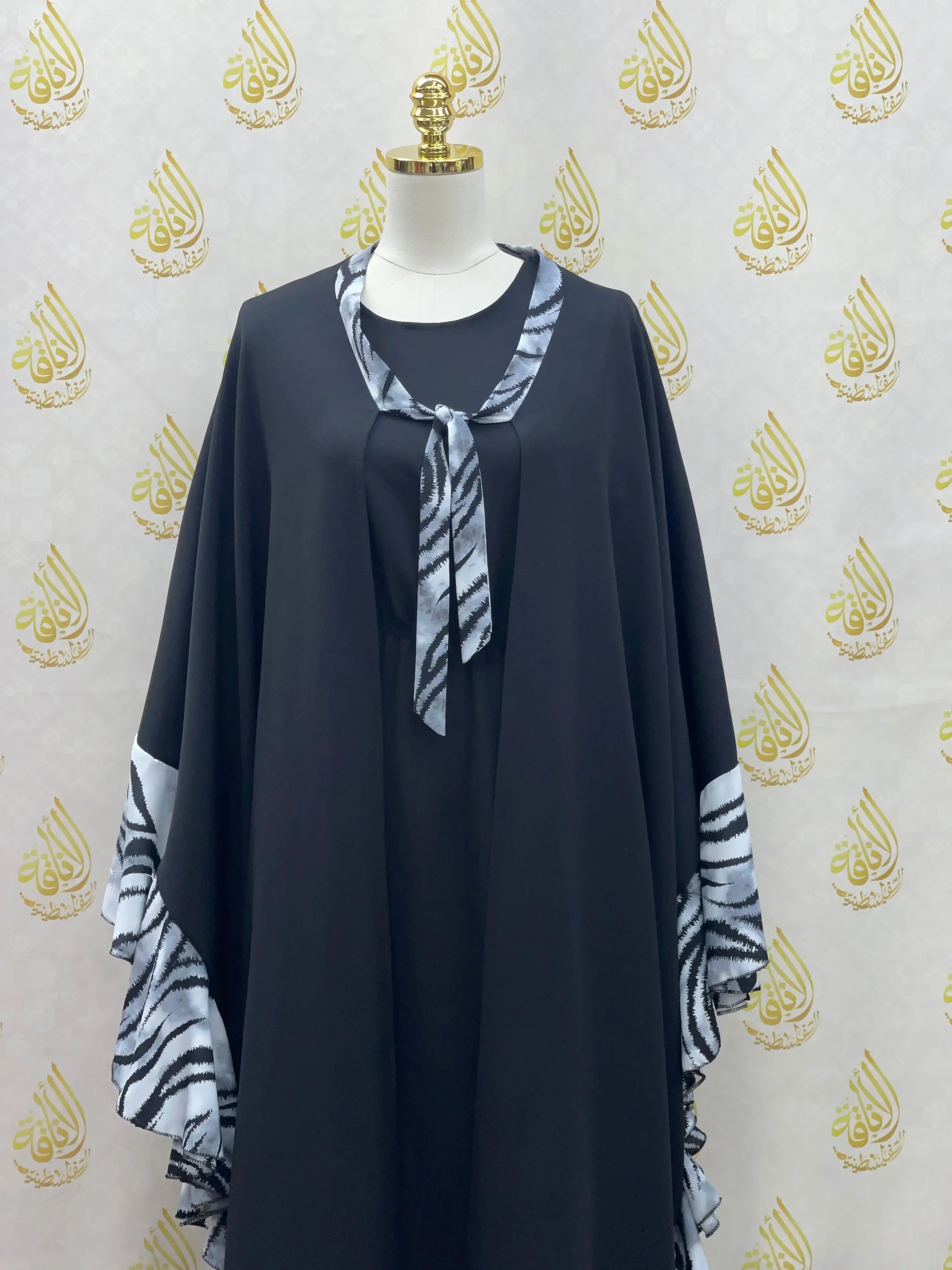 Black butterfly abaya dress with zebra print trim on sleeves and neckline by Palestinian Elegance
