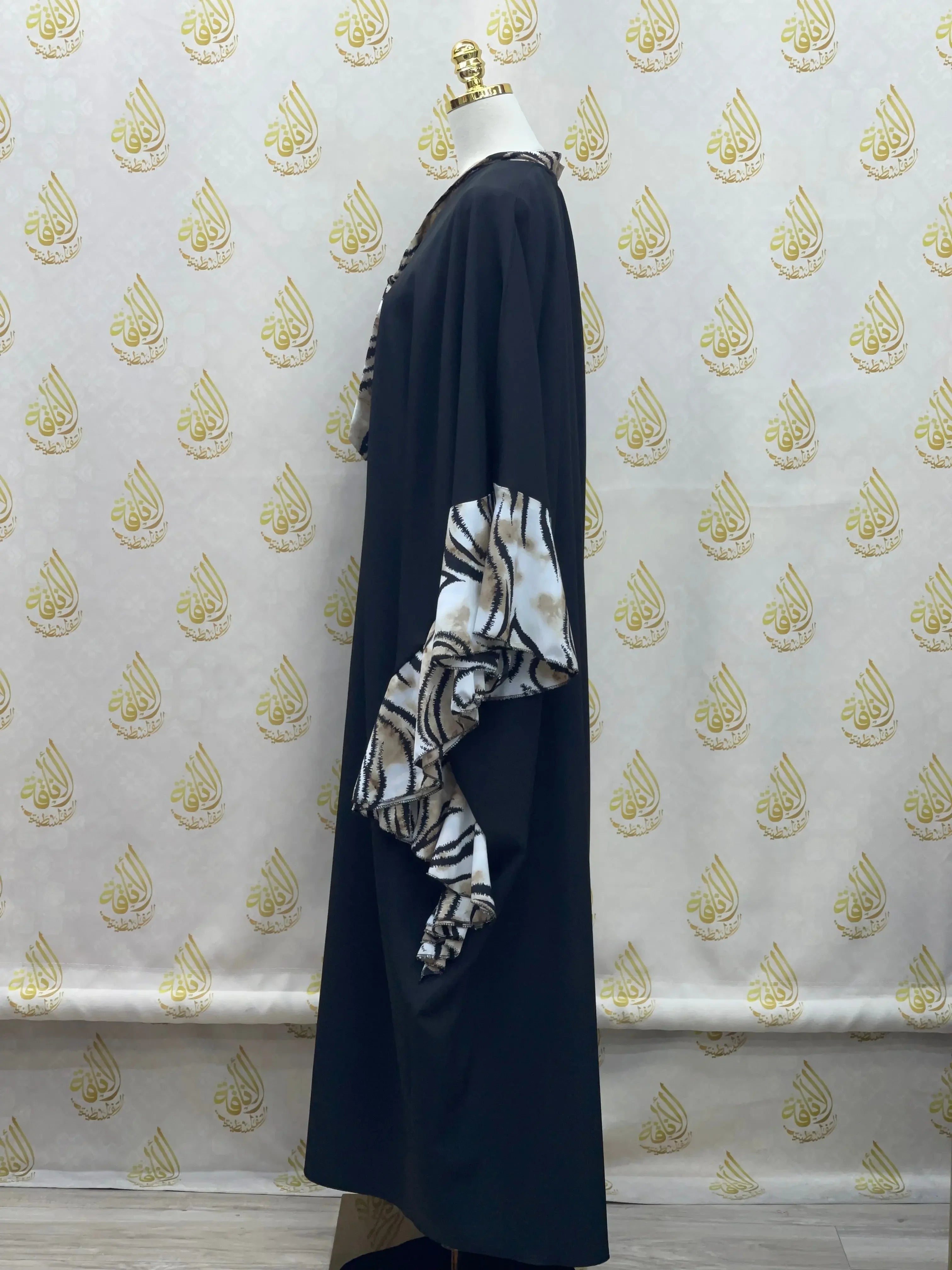 Palestinian Elegance butterfly abaya dress in black with unique patterned butterfly sleeves on a mannequin