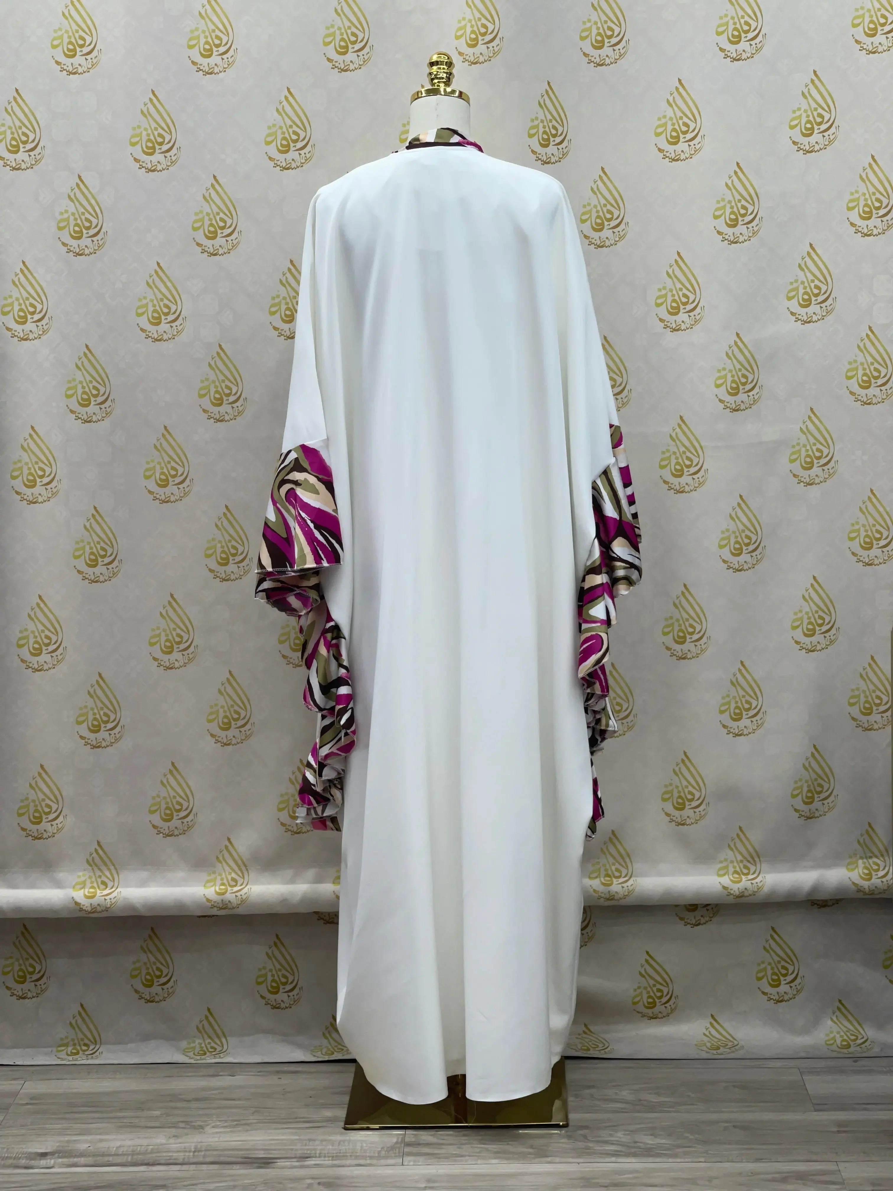 Palestinian Elegance white butterfly abaya dress with pink and purple patterned sleeves displayed on mannequin