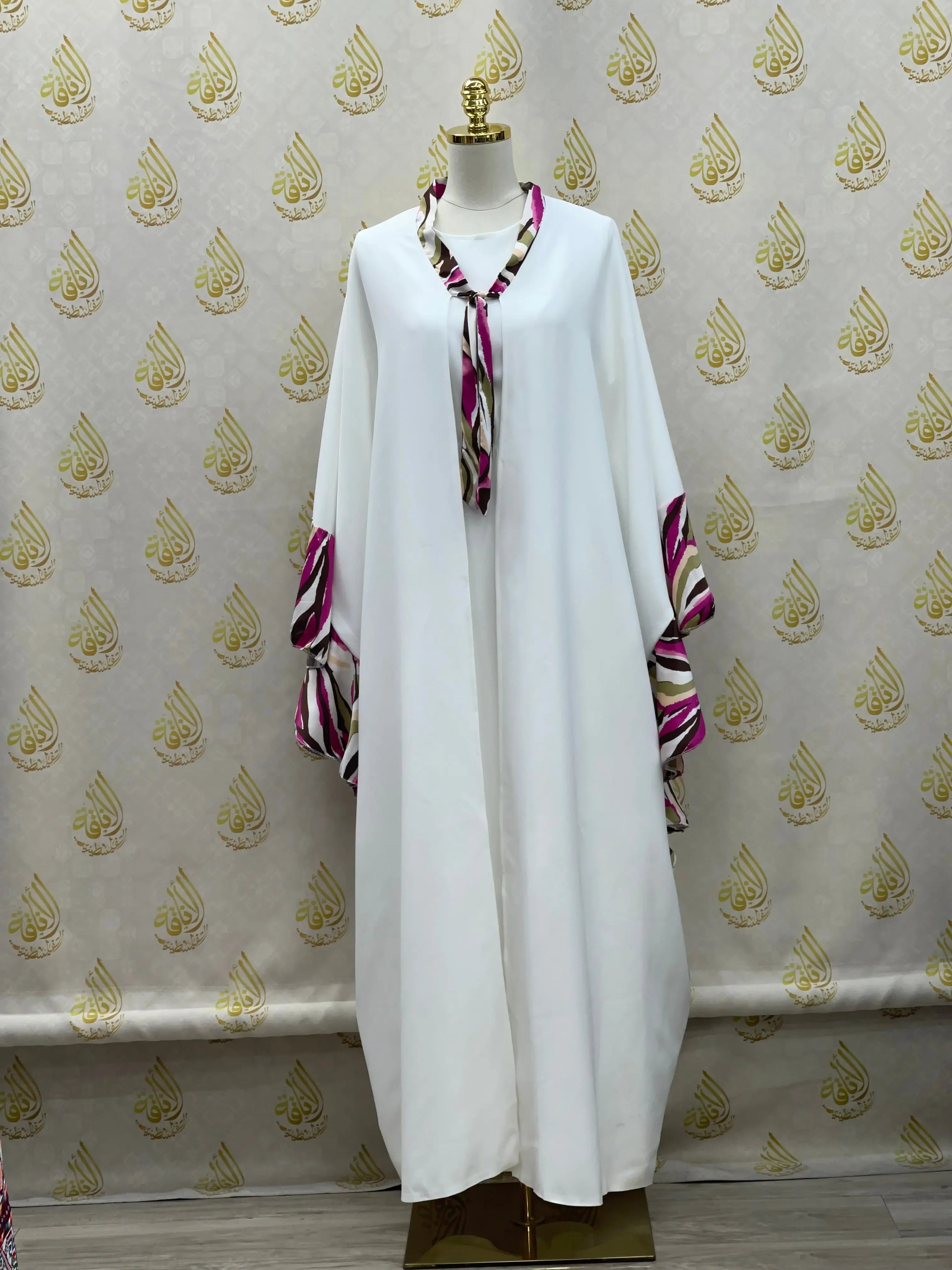 White butterfly abaya dress by Palestinian Elegance with purple striped accents on sleeves and collar