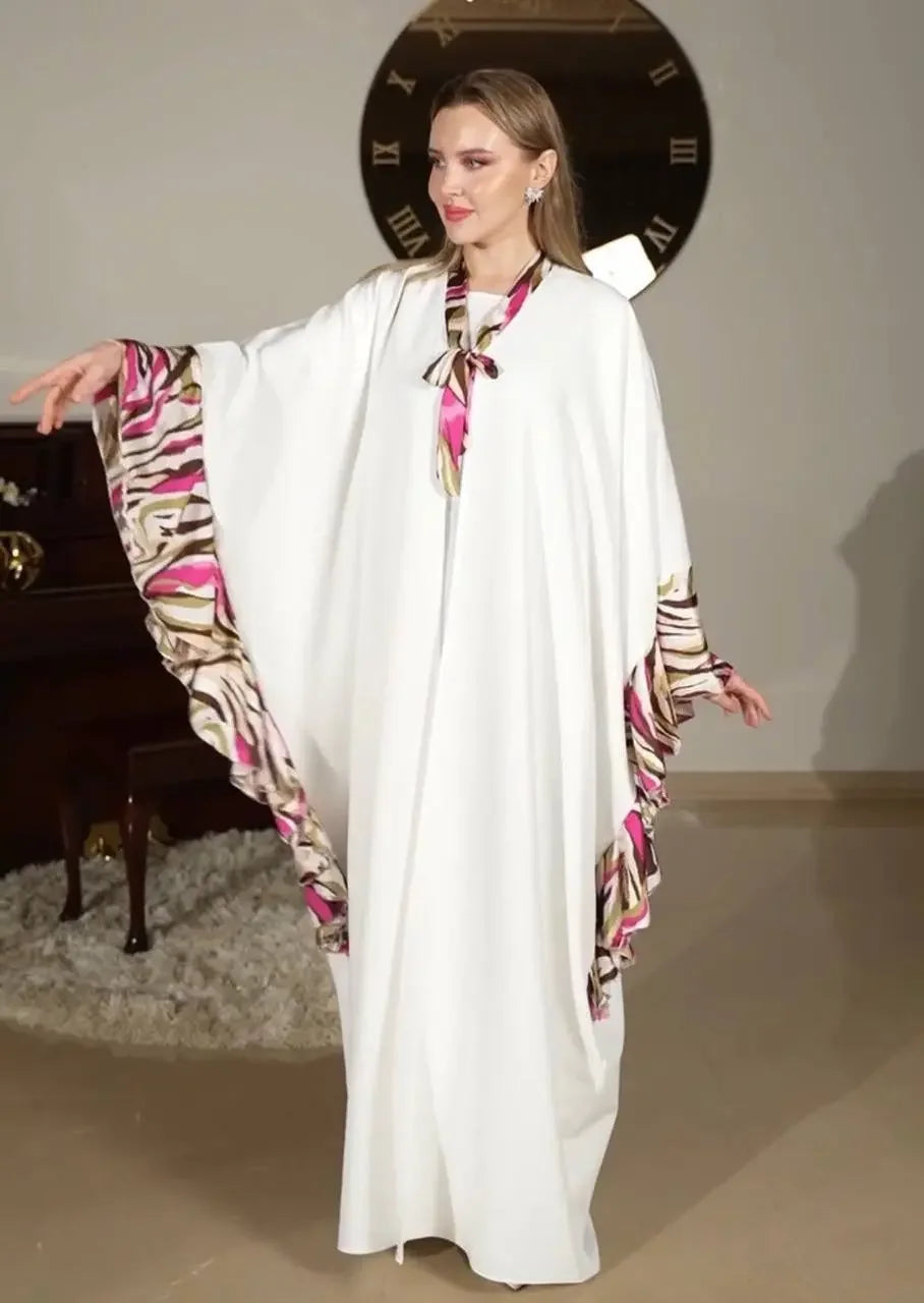 Palestinian Elegance white butterfly abaya dress with pink and brown printed edges worn by model indoors