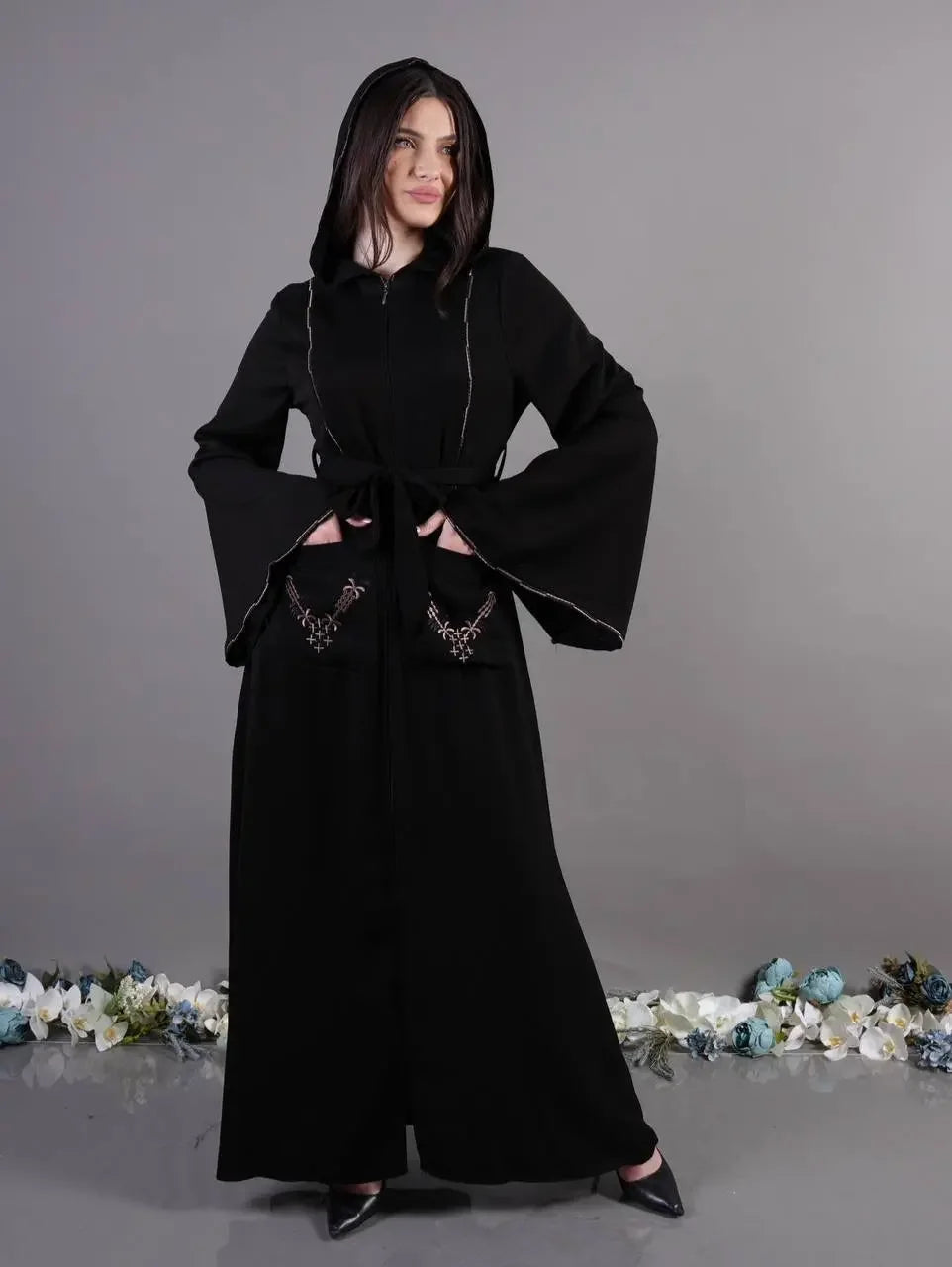 Palestinian Elegance black chic pocket abaya with wide sleeves and hood worn by model