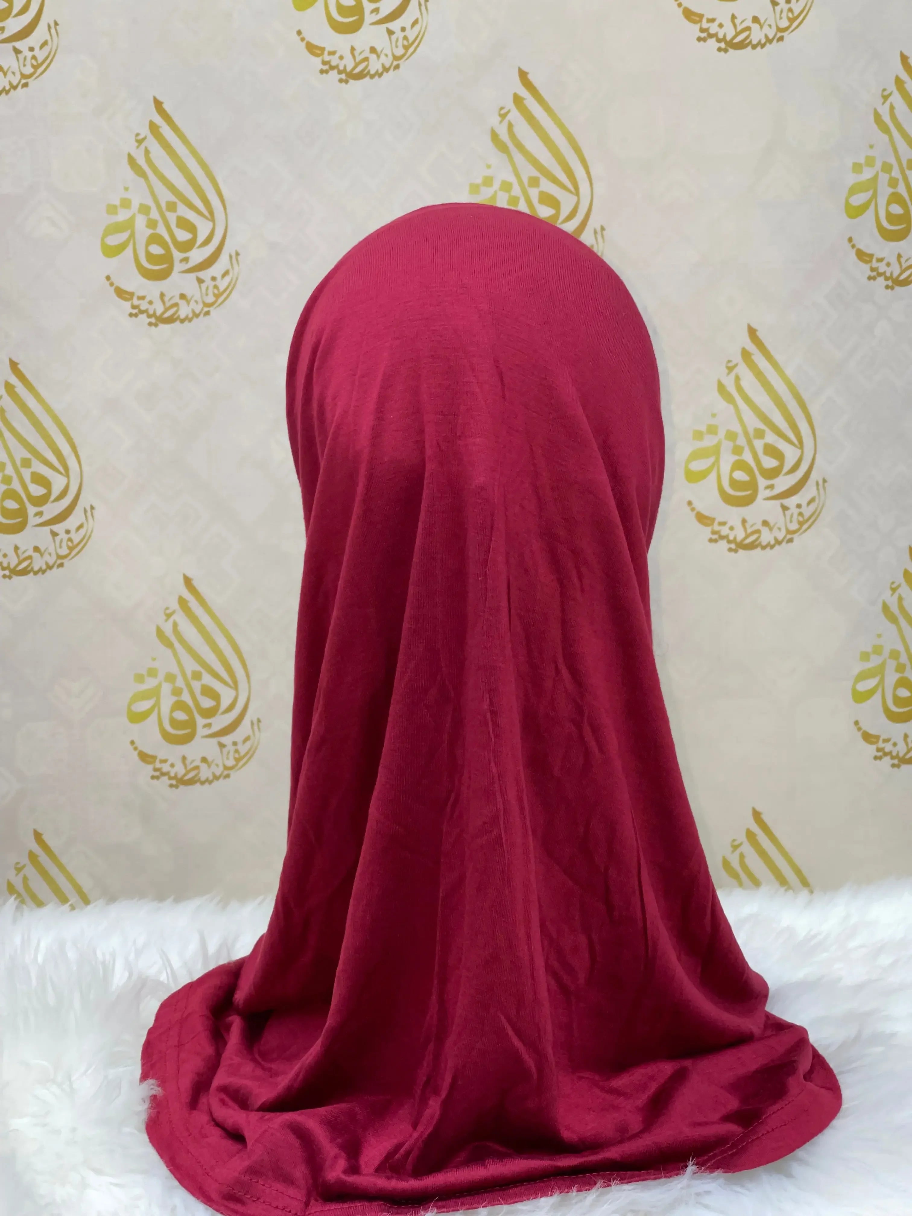 Rich red cotton hijab for women by Palestinian Elegance displayed on a mannequin against decorative background