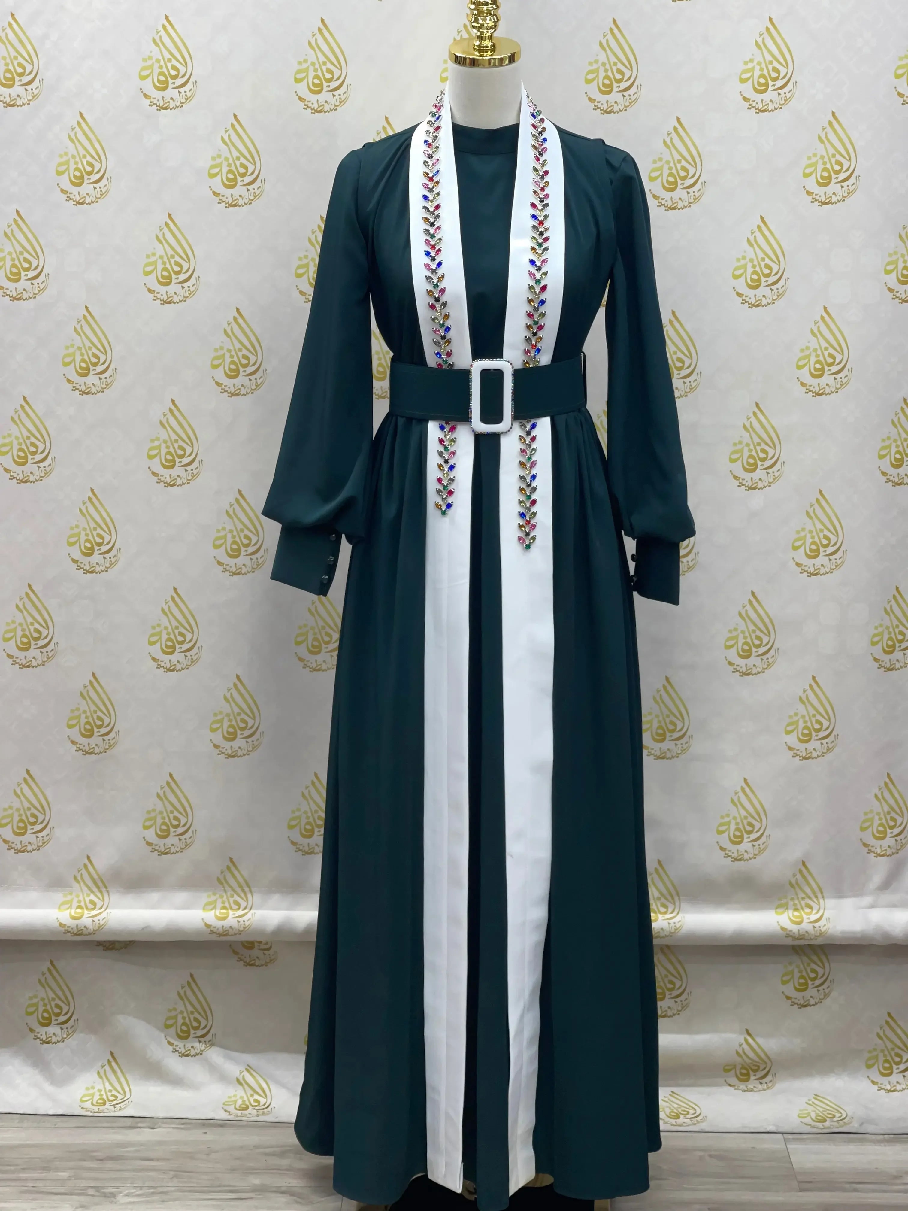 Palestinian Elegance crystal kaftan dress in dark green with white embroidery and a black belt