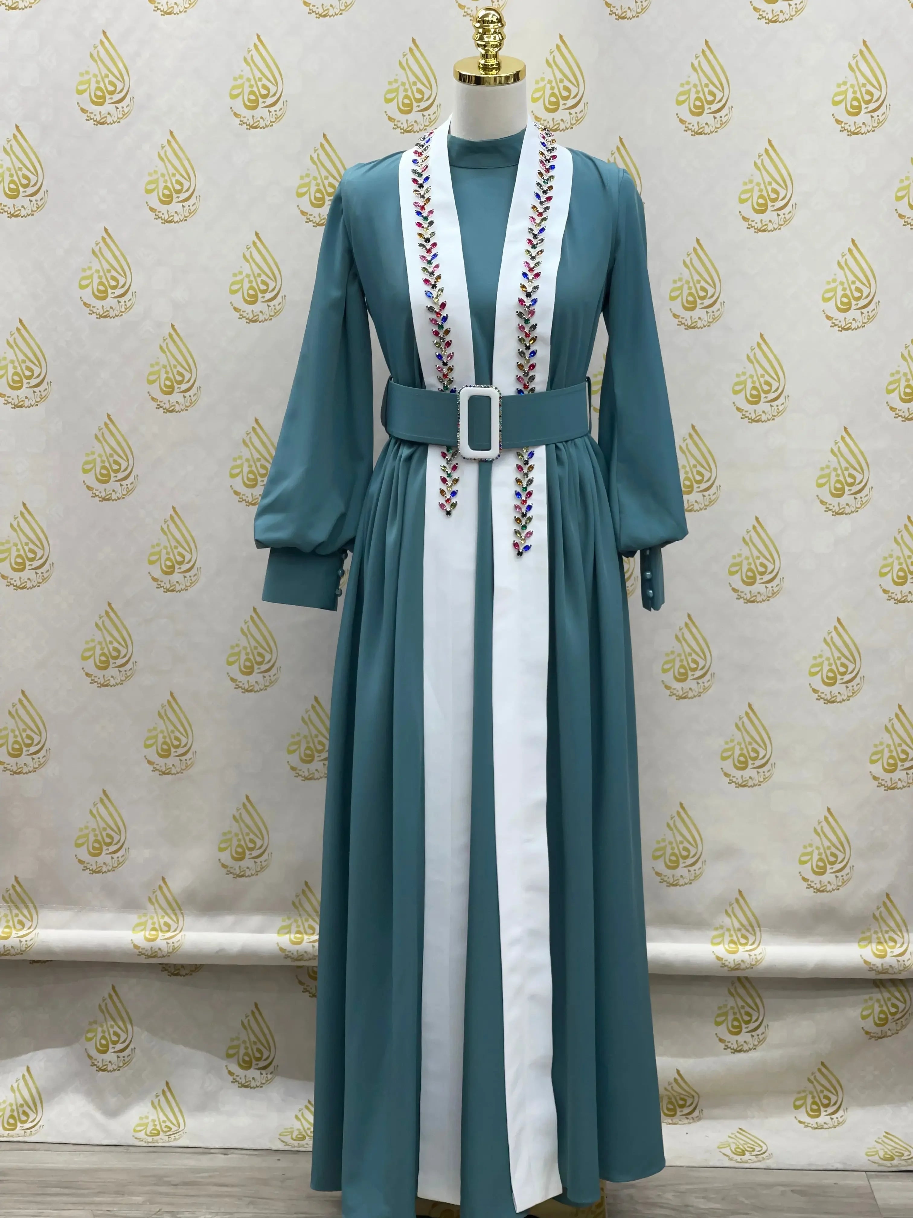 Crystal kaftan dress by Palestinian Elegance in teal with embroidered accents and wide belt