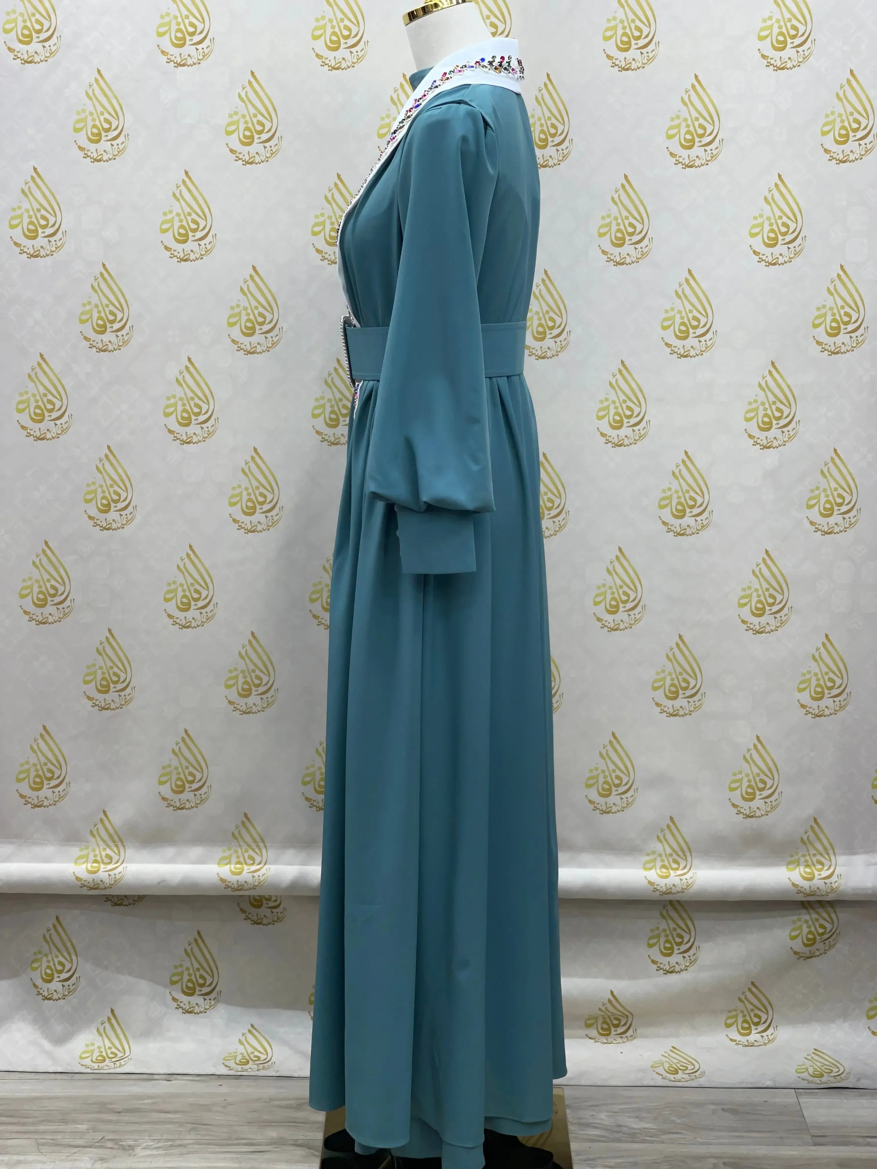 Palestinian Elegance crystal kaftan dress in teal with long sleeves and detailed neckline