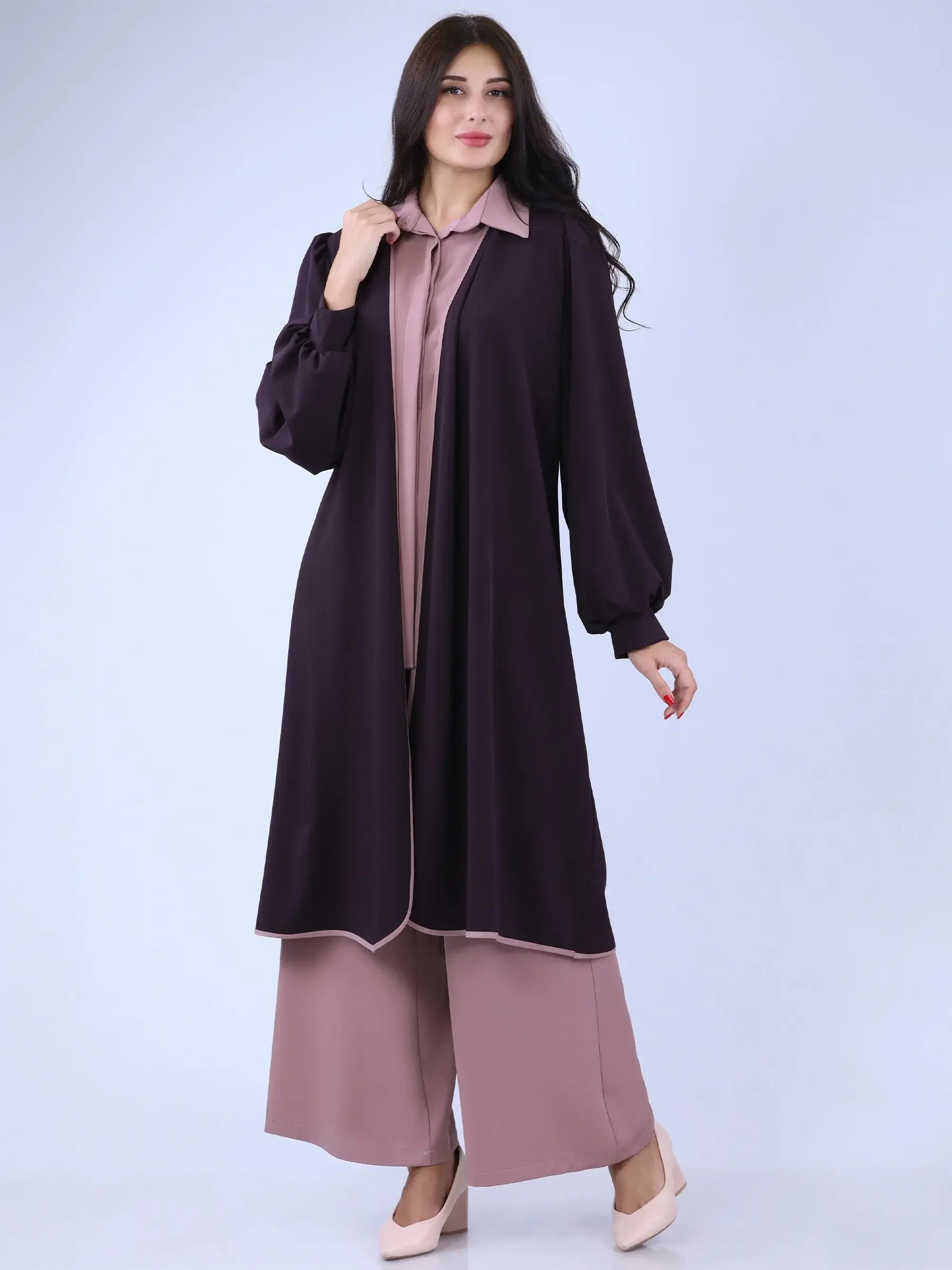 Palestinian Elegance long black cardigan with puff sleeves worn over mauve outfit by woman