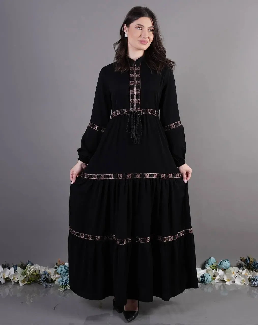 Palestinian Elegance black elegant abaya dress with decorative trim worn by woman