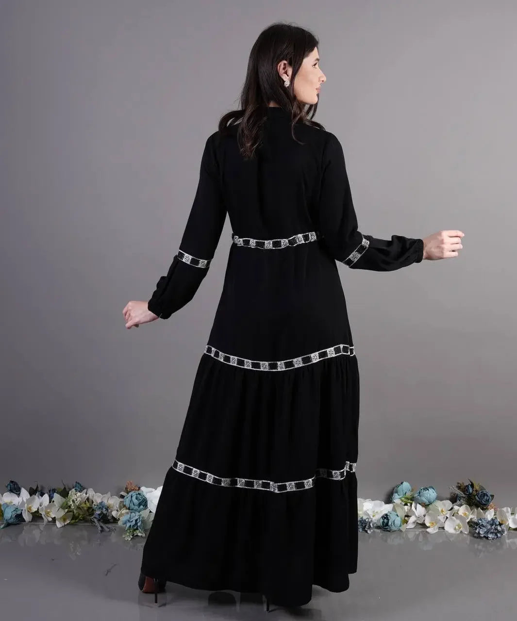 Back view of elegant abaya dress by Palestinian Elegance in black with decorative silver trim