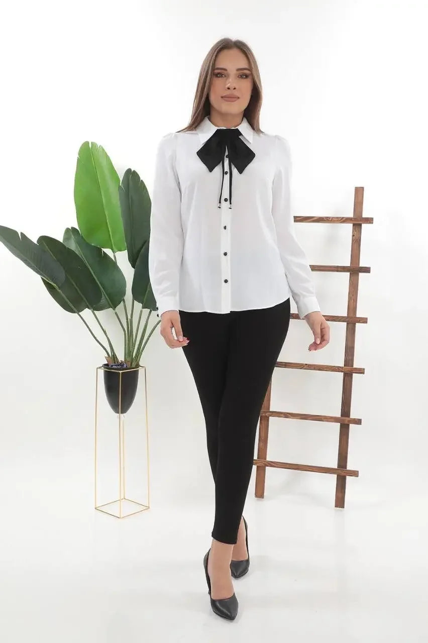 Woman wearing Palestinian Elegance elegant bow tie blouse in white with black bow and black pants