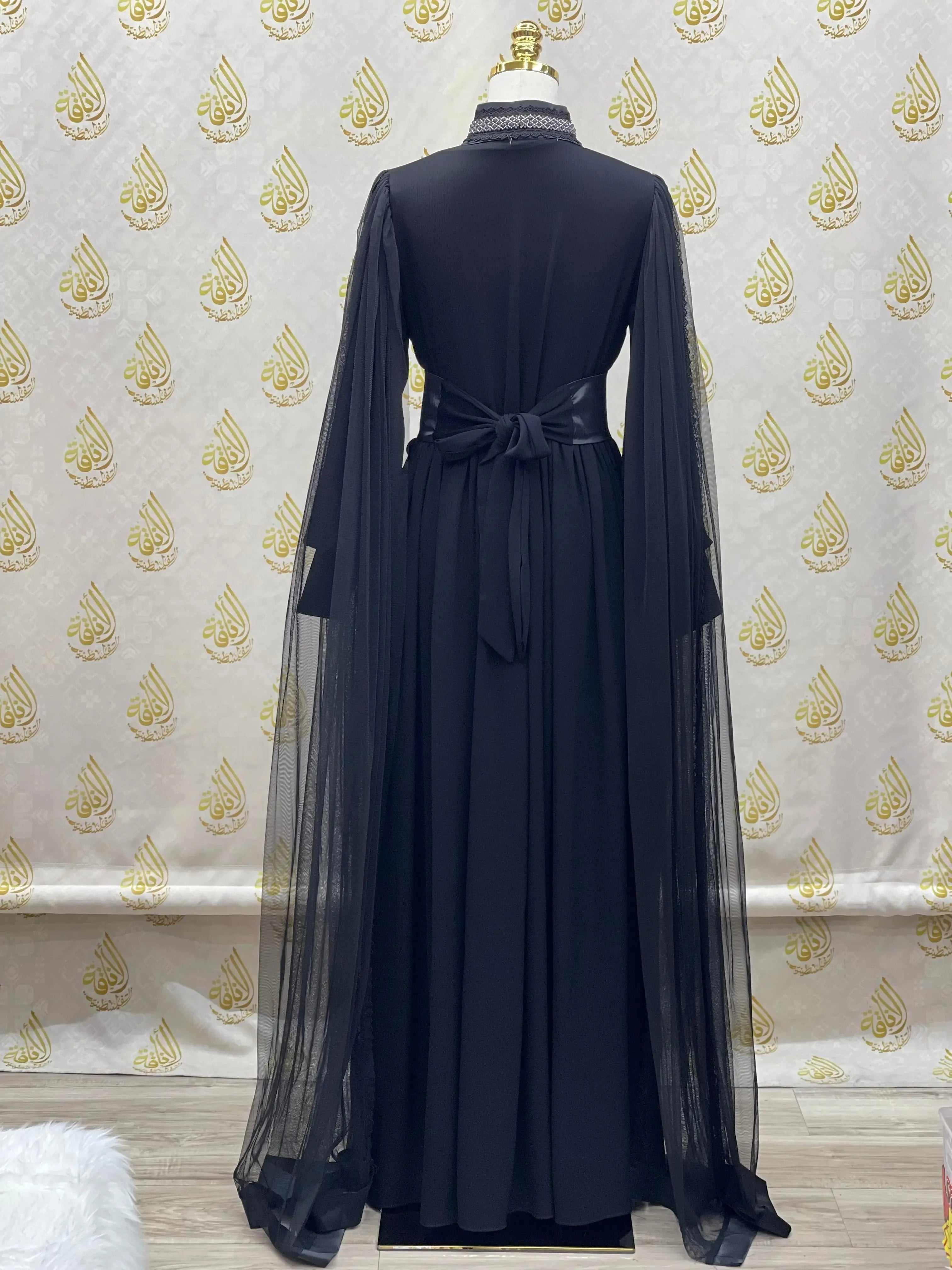 Palestinian Elegance black elegant modest formal dress with sheer long sleeves and a tied waist bow