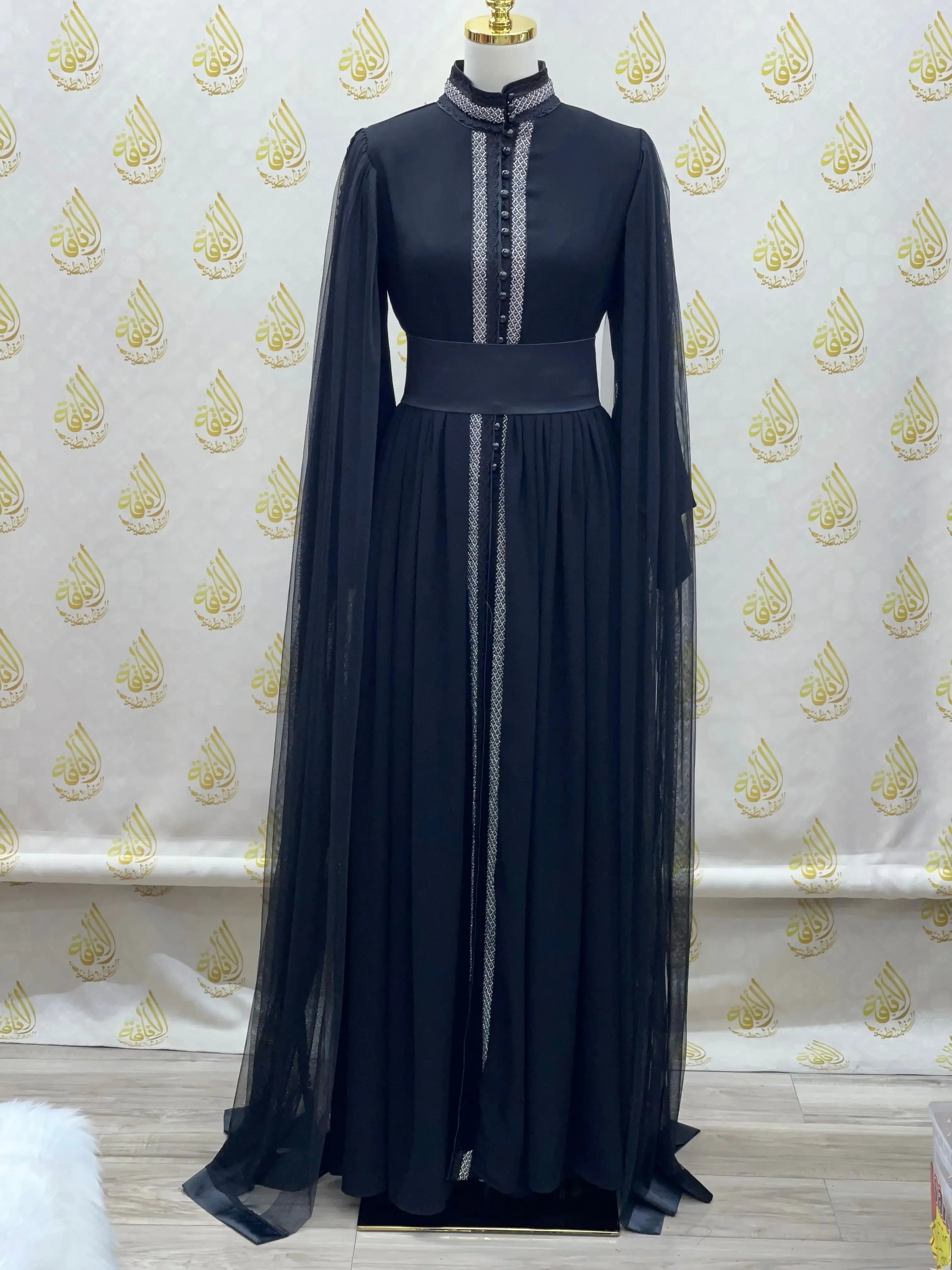 Elegant modest formal dress by Palestinian Elegance featuring long flowing sleeves and intricate front detailing