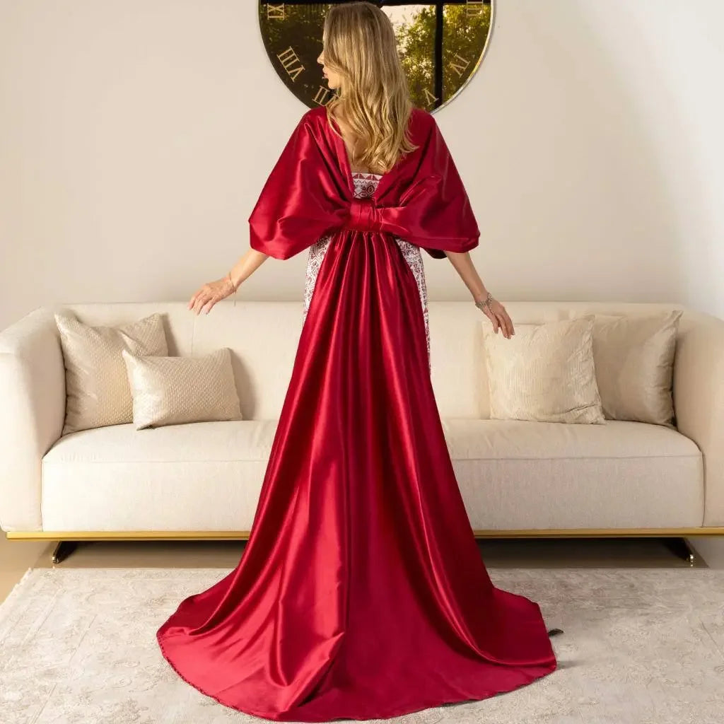 Elegant Palestinian thoub dress in rich red satin with flowing train and bow detail from Palestinian Elegance