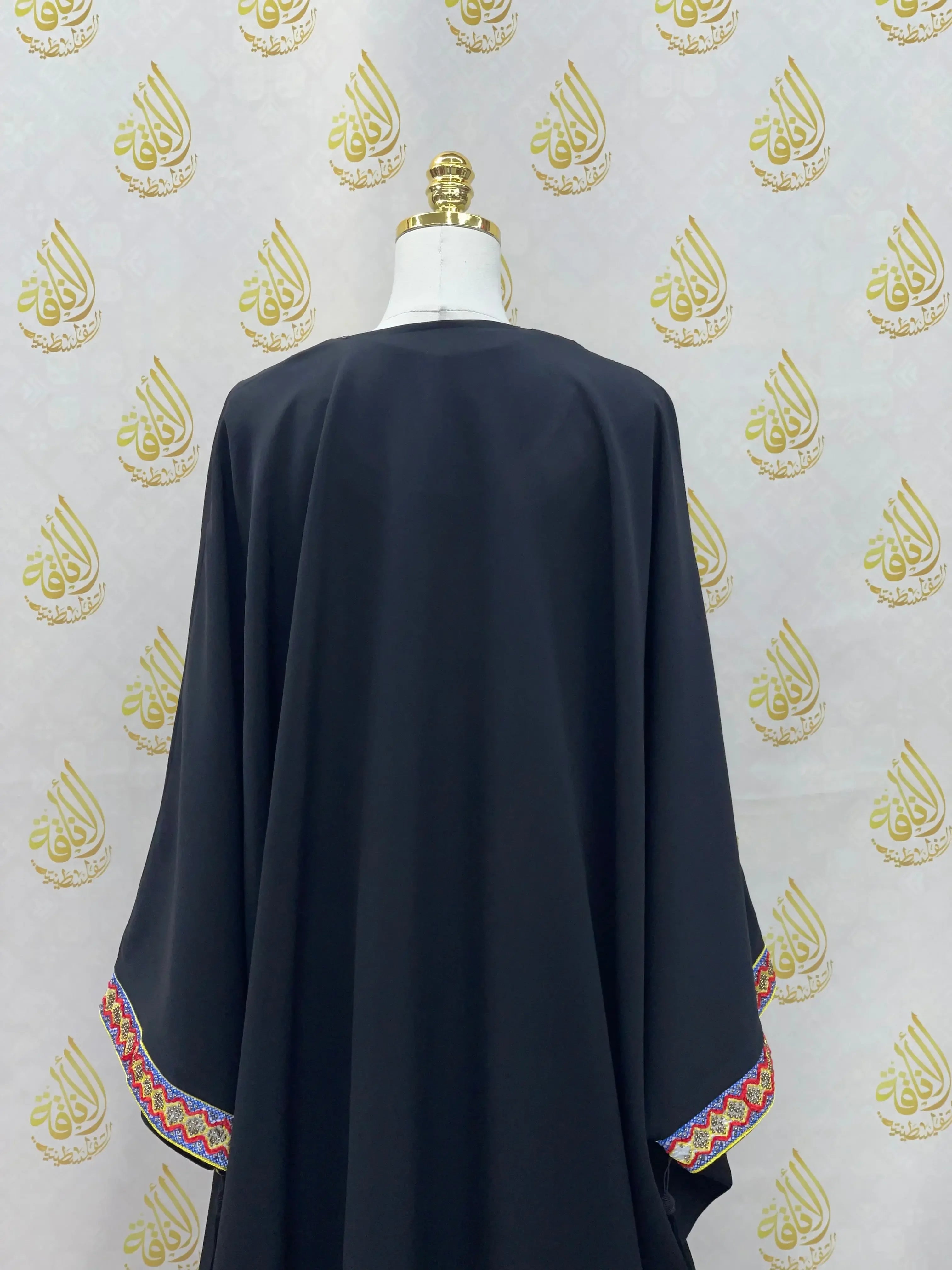 Back view of Palestinian Elegance black embroidered abaya dress with colorful detailed sleeve accents