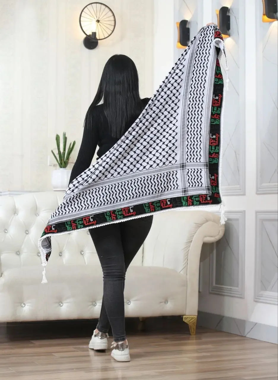 Woman holding a large embroidered kuffiyeh scarf by Palestinian Elegance with traditional black and white pattern