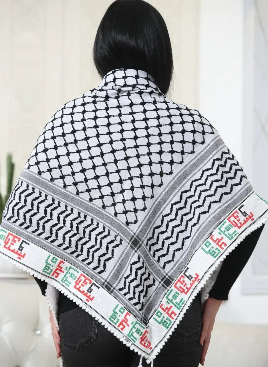 Woman wearing embroidered kuffiyeh scarf with black and white traditional patterns and colorful border