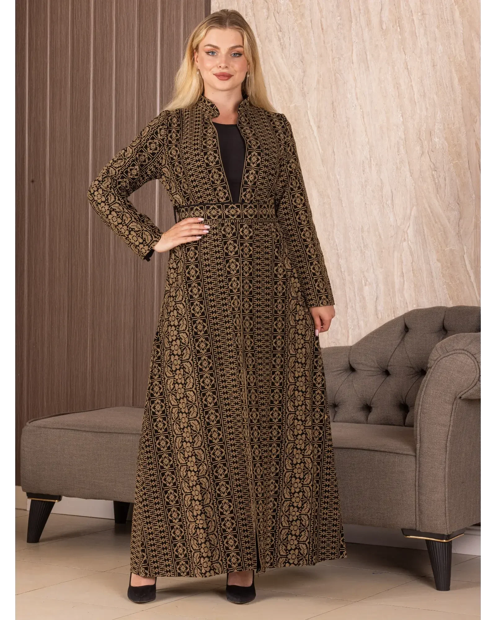 Palestinian Elegance embroidered long cardigan in black and gold worn by a model standing indoors