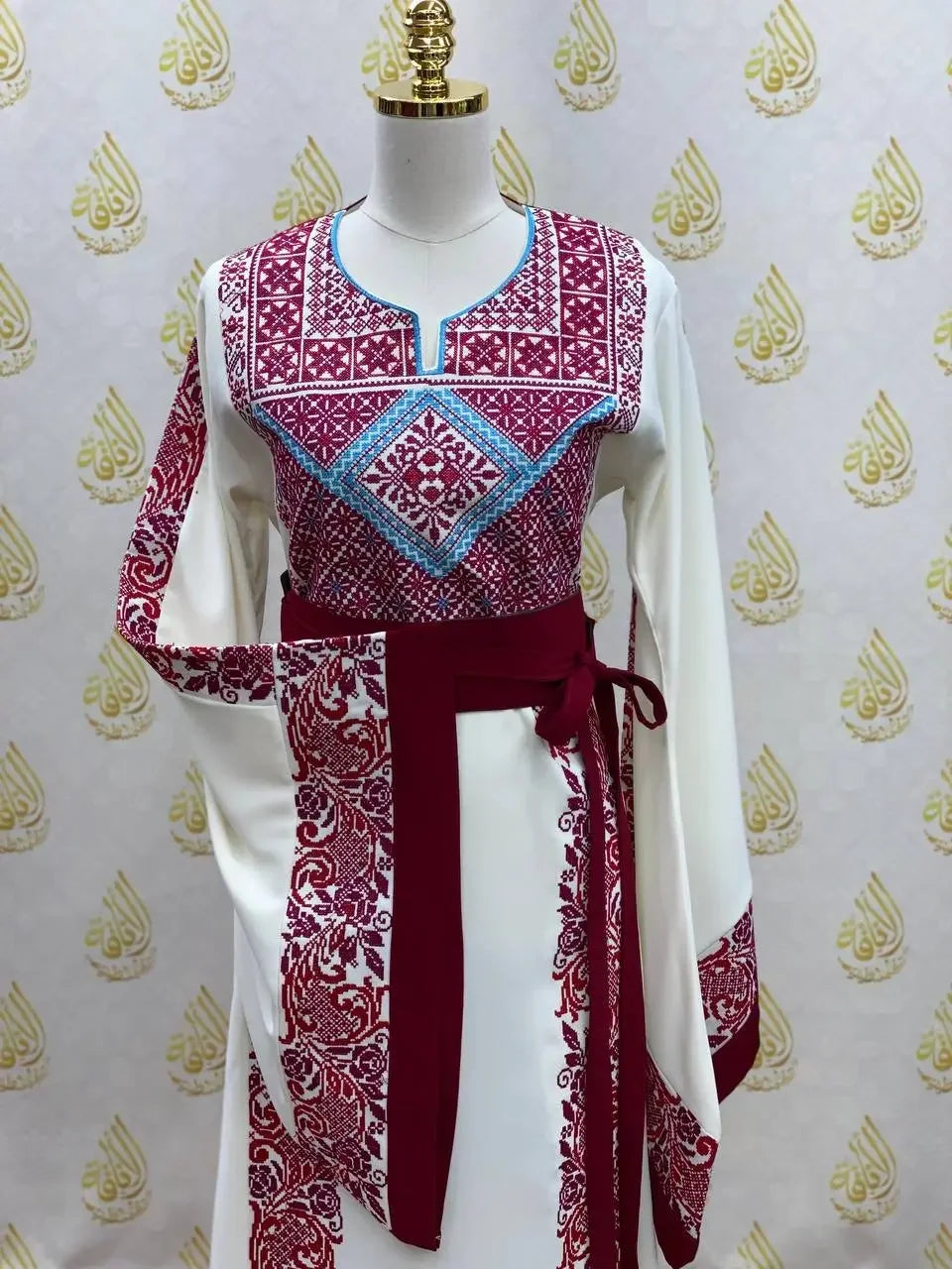 Palestinian Elegance embroidered modest fashion dress with red and blue traditional embroidery on white fabric