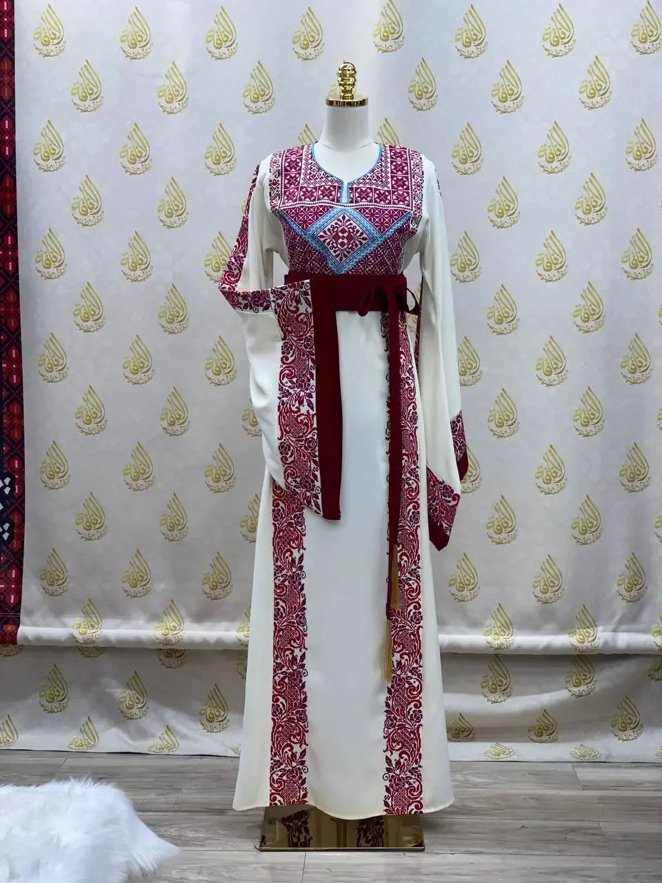 Embroidered modest fashion dress with intricate red and blue embroidery and maroon sash by Palestinian Elegance