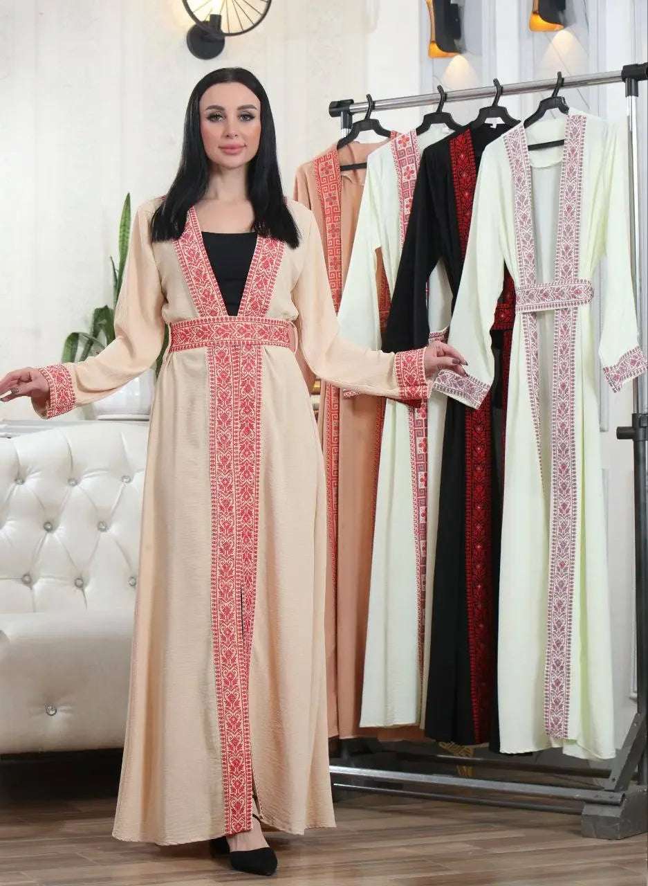 Palestinian Elegance embroidered open cardigan in beige with red intricate embroidery worn by model with other color options hanging on rack