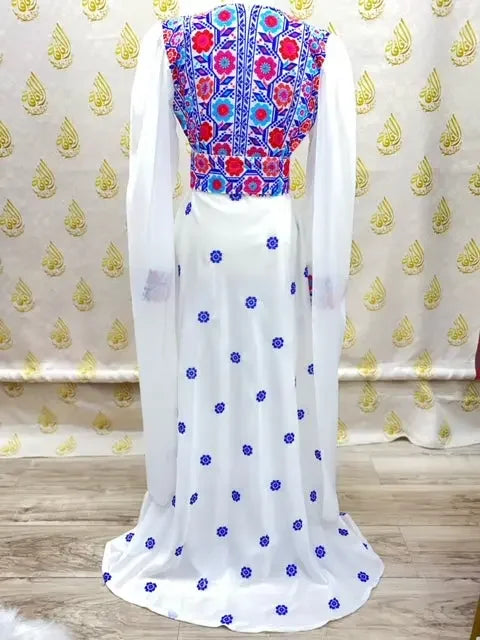 Embroidered Palestinian dress with vibrant multicolor floral patterns on white fabric by Palestinian Elegance