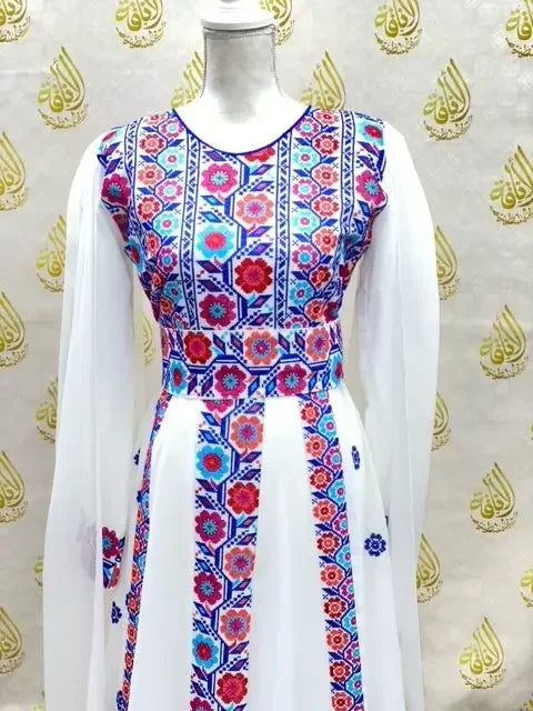 White embroidered Palestinian dress with colorful floral patterns by Palestinian Elegance