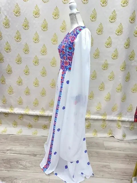 White embroidered Palestinian dress with colorful floral embroidery from Palestinian Elegance on a mannequin