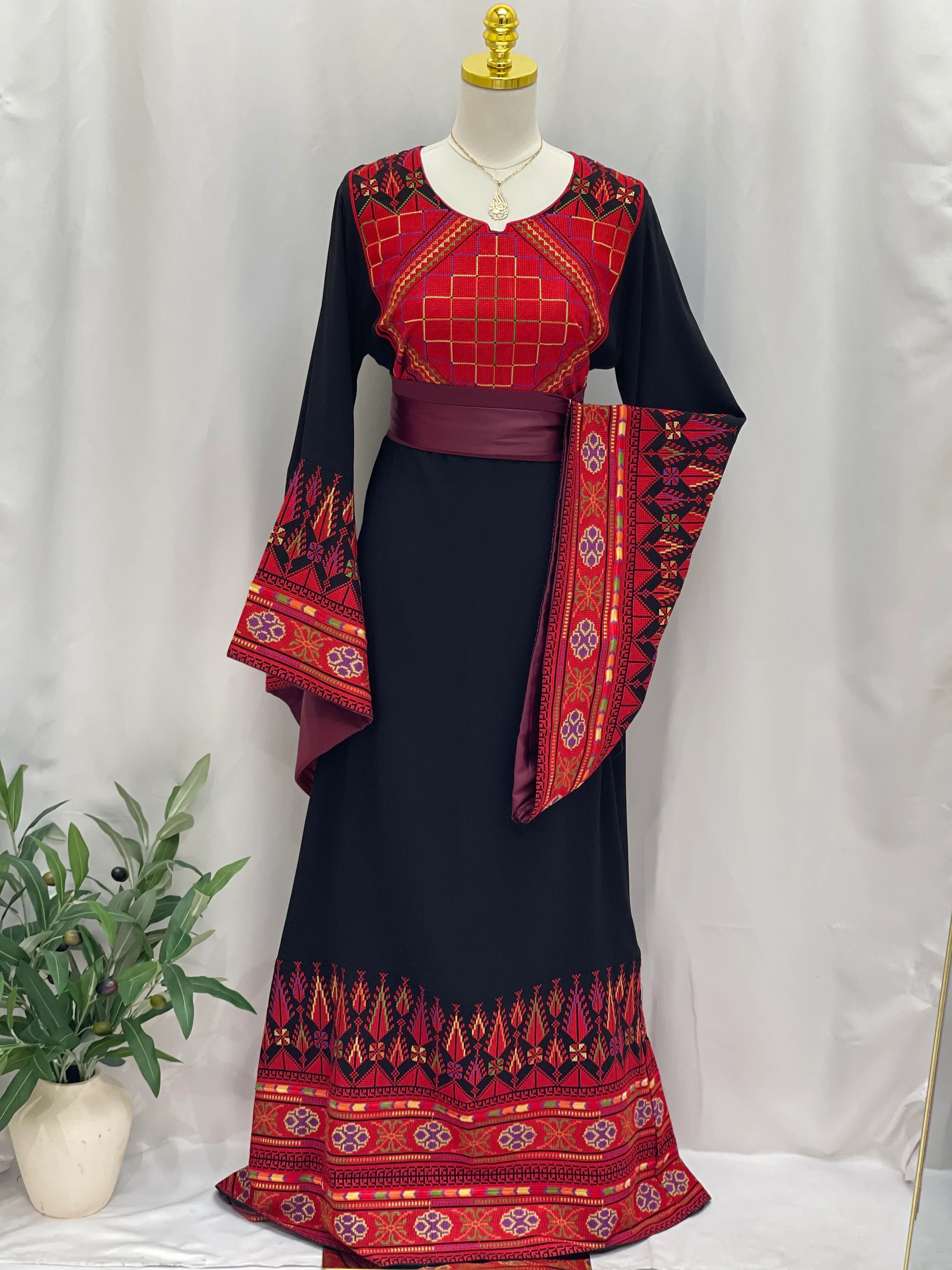 Embroidered Palestinian thoub dress in black with red traditional patterns and wide sleeves by Palestinian Elegance