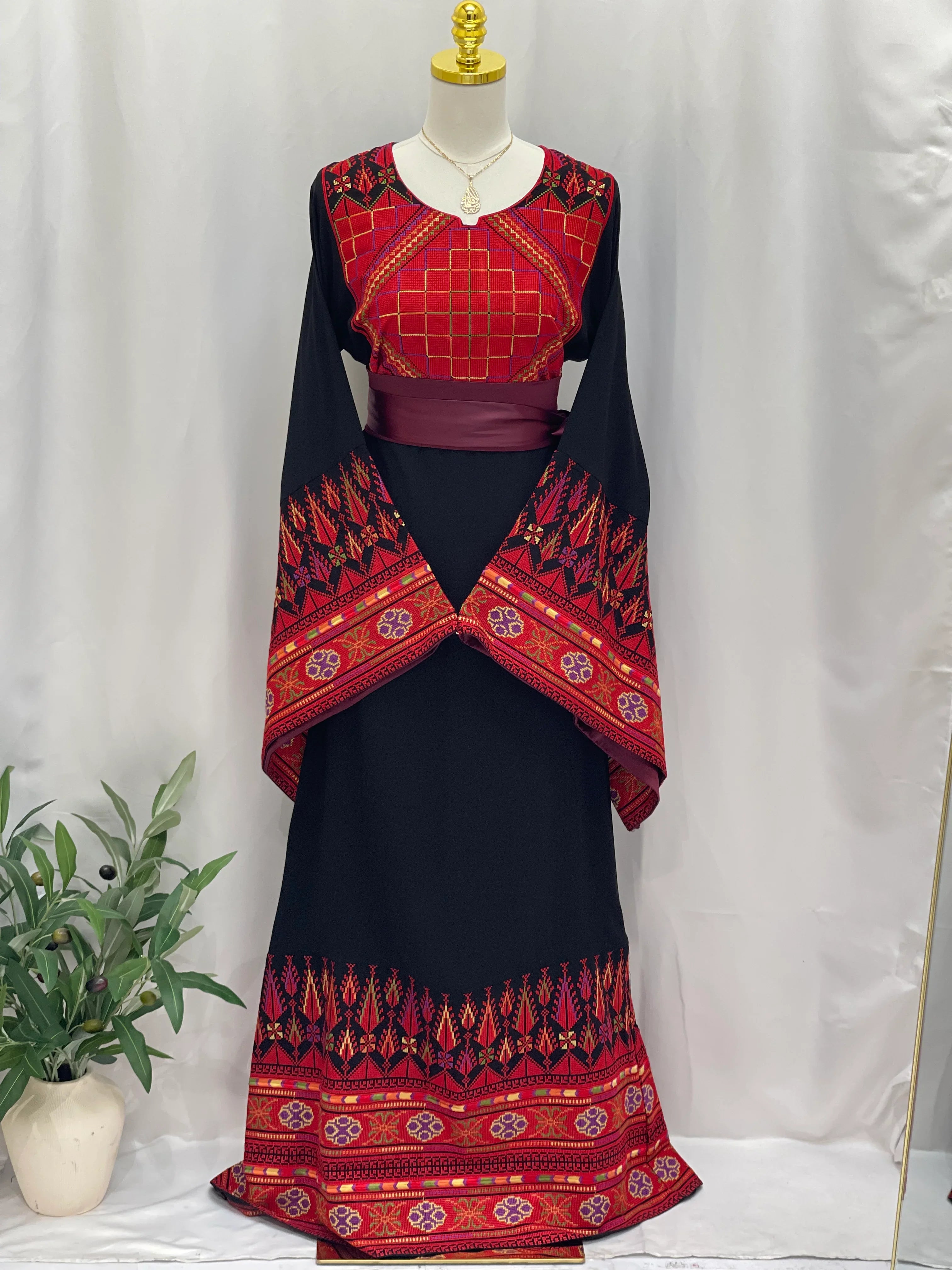 Embroidered Palestinian thoub dress by Palestinian Elegance featuring red and black traditional geometric patterns