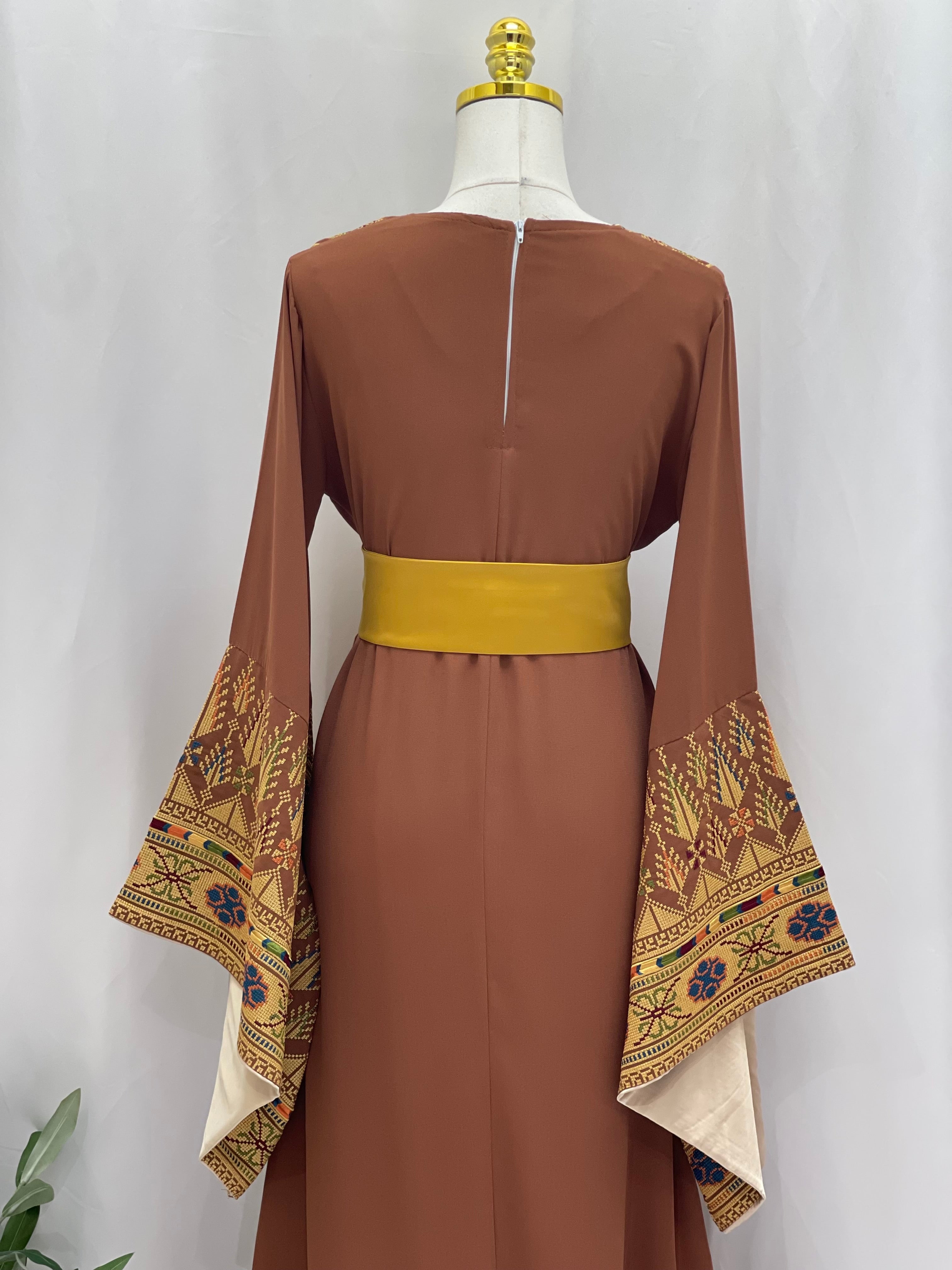 Brown embroidered Palestinian thoub dress with wide sleeves featuring detailed traditional embroidery and a yellow belt