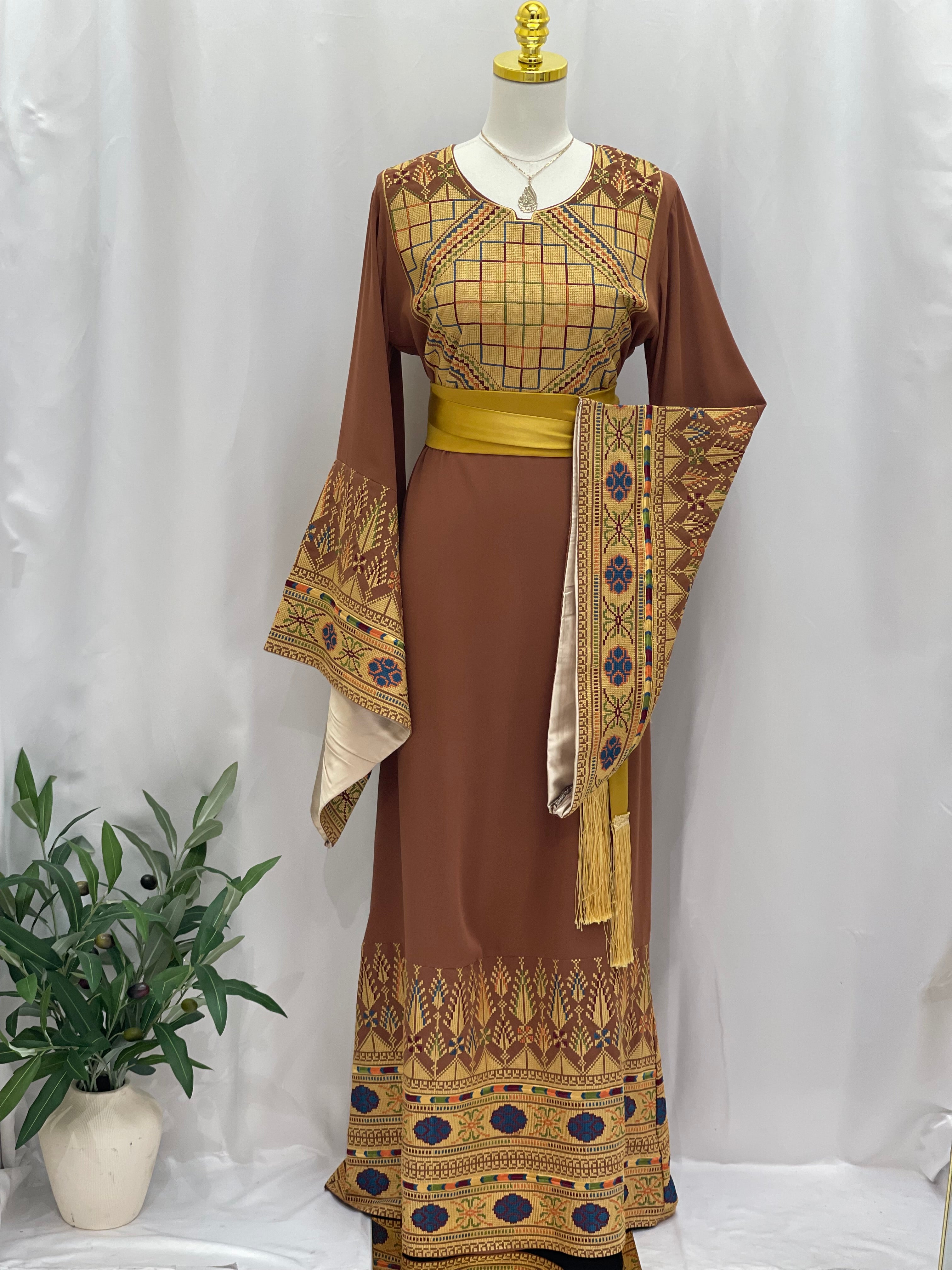 Embroidered Palestinian thoub dress in brown with intricate traditional patterns and yellow sash