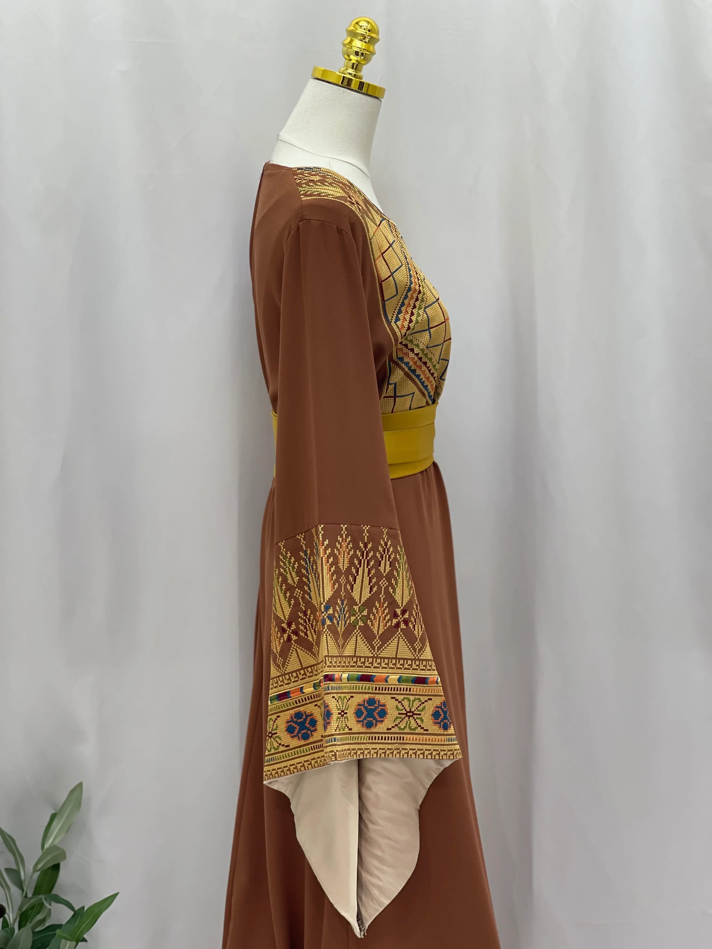 Embroidered Palestinian thoub dress in brown with intricate golden and colorful embroidery on sleeves and chest