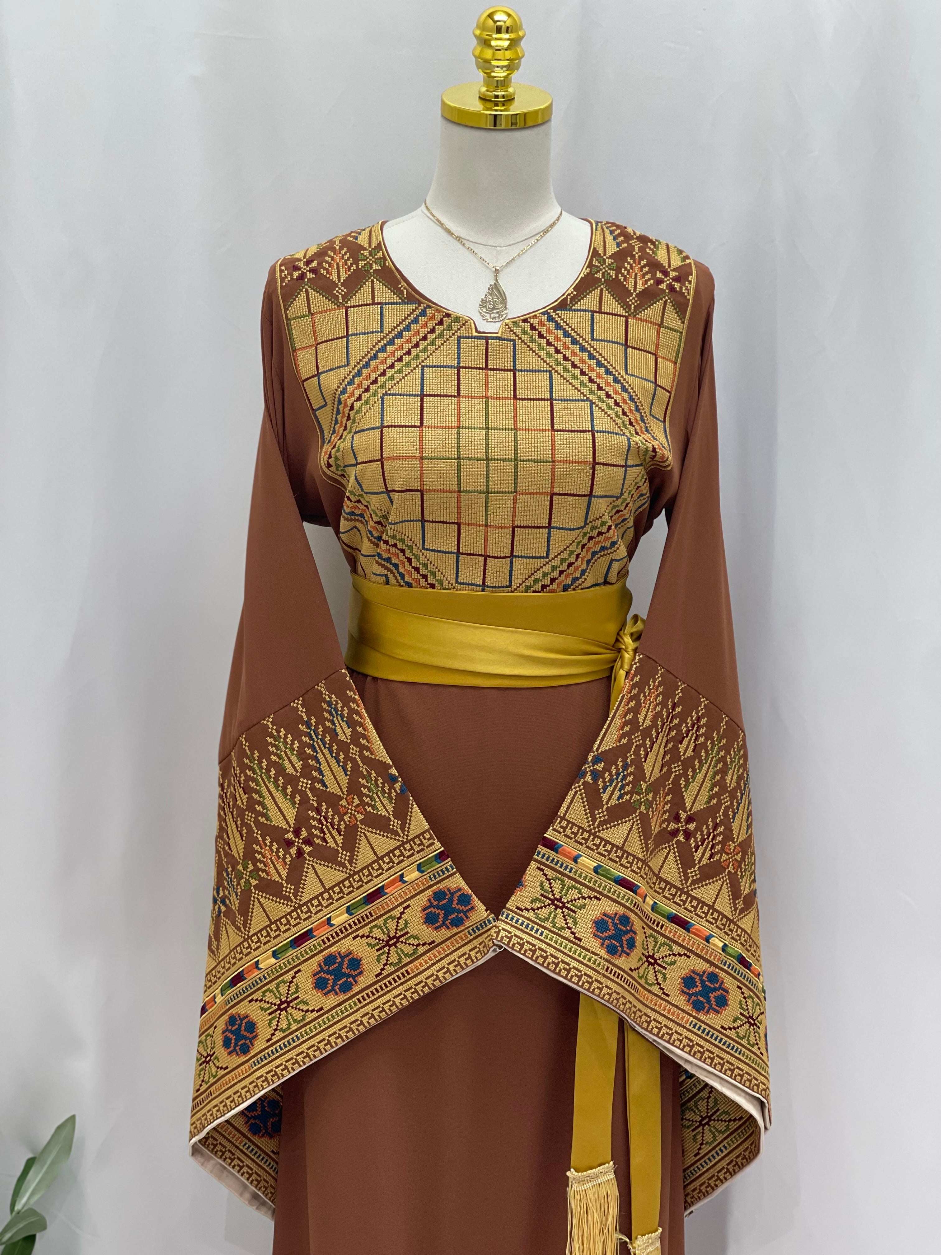 Embroidered Palestinian thoub dress with intricate geometric patterns and yellow sash by Palestinian Elegance