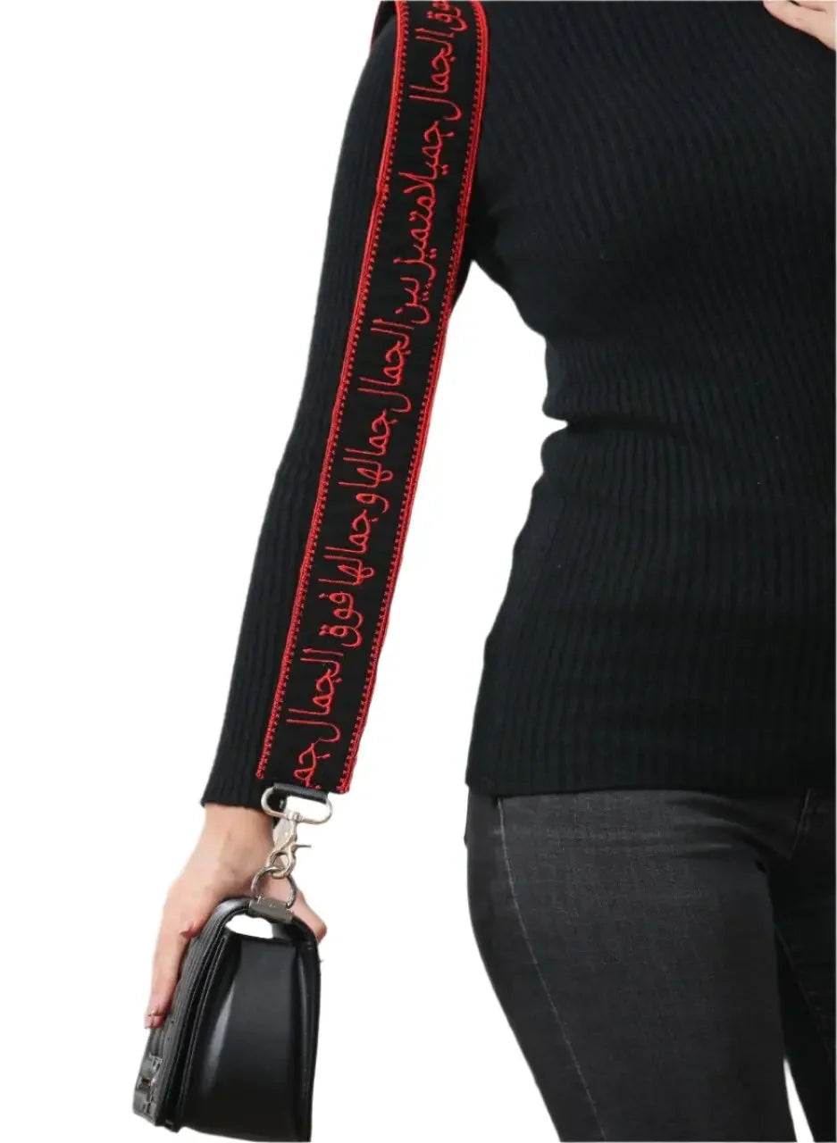 Black embroidered purse with poetic strap featuring red Arabic calligraphy from Palestinian Elegance