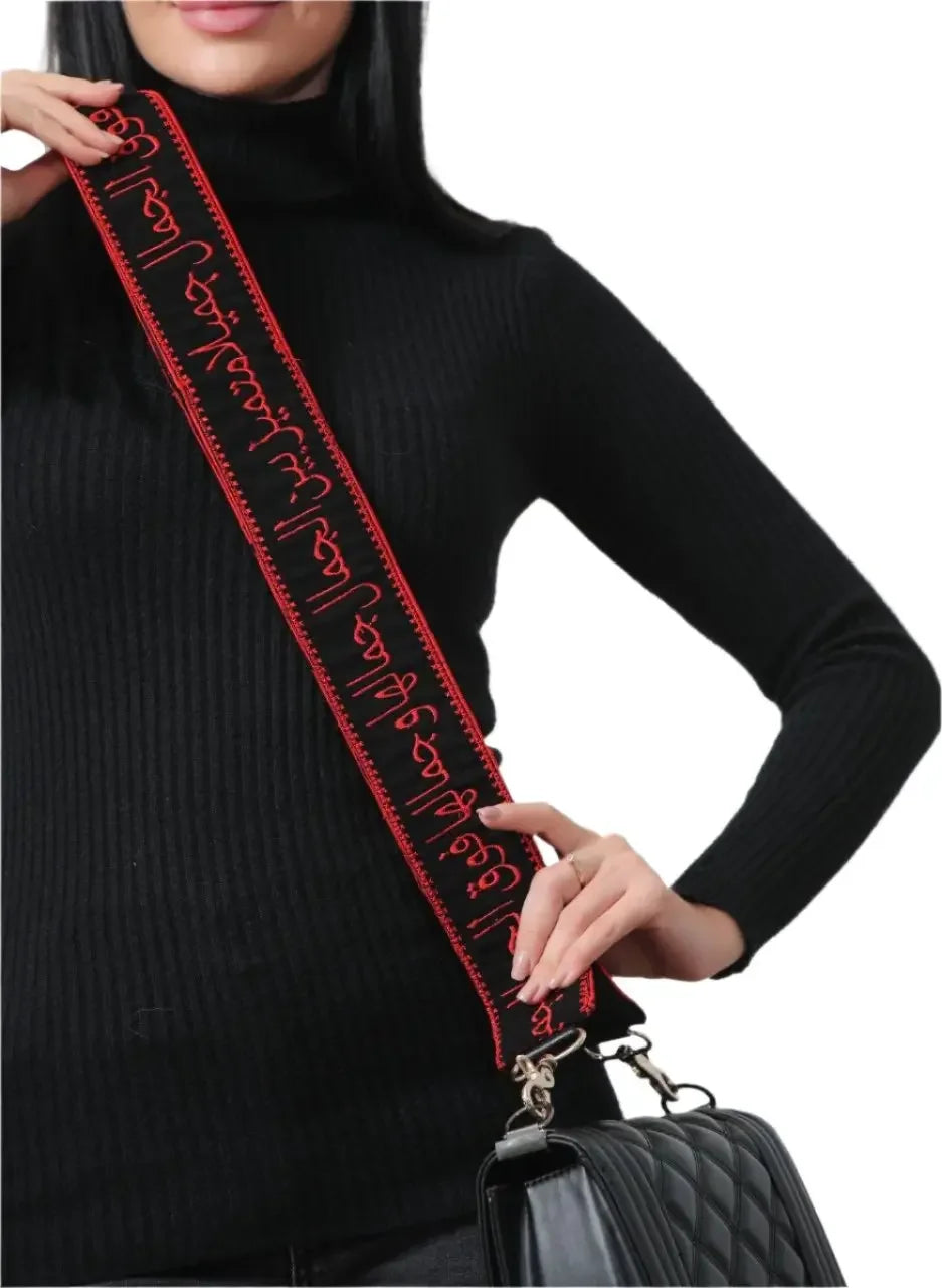 Embroidered purse with poetic strap in black and red worn by model from Palestinian Elegance