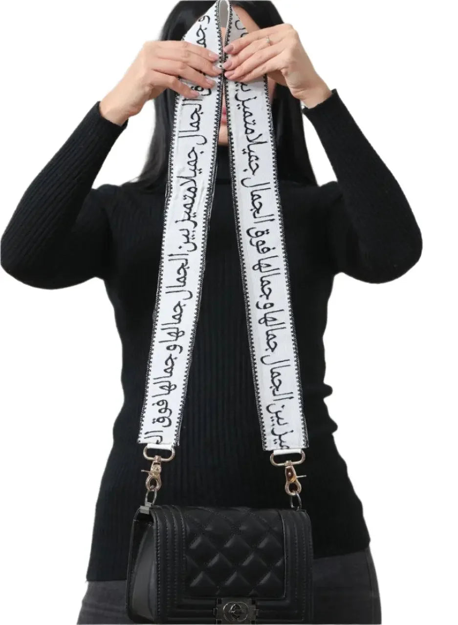 Black quilted handbag featuring an embroidered purse with poetic strap held by a woman in black