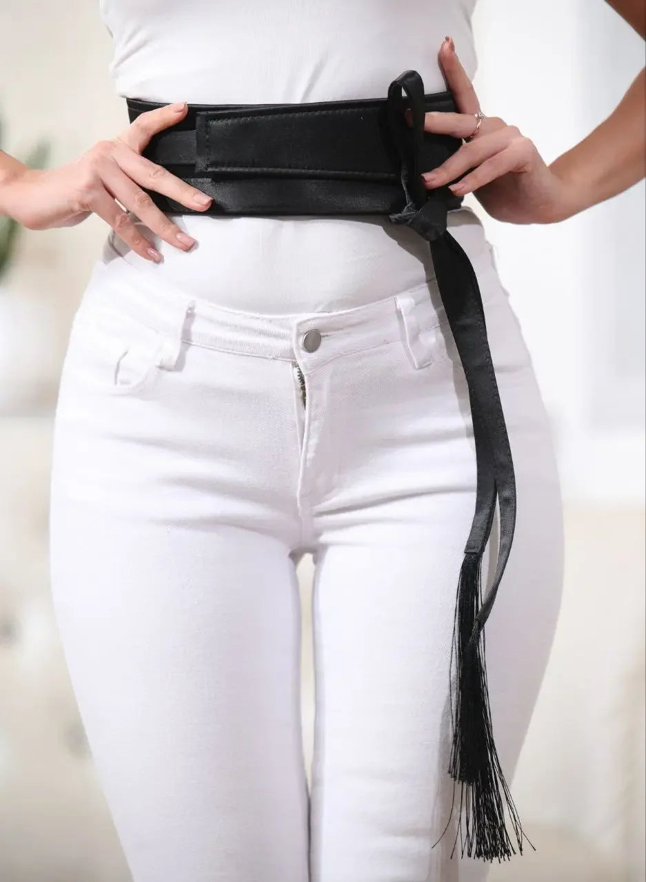 Black embroidered satin belt from Palestinian Elegance styled over white outfit with tassel detail